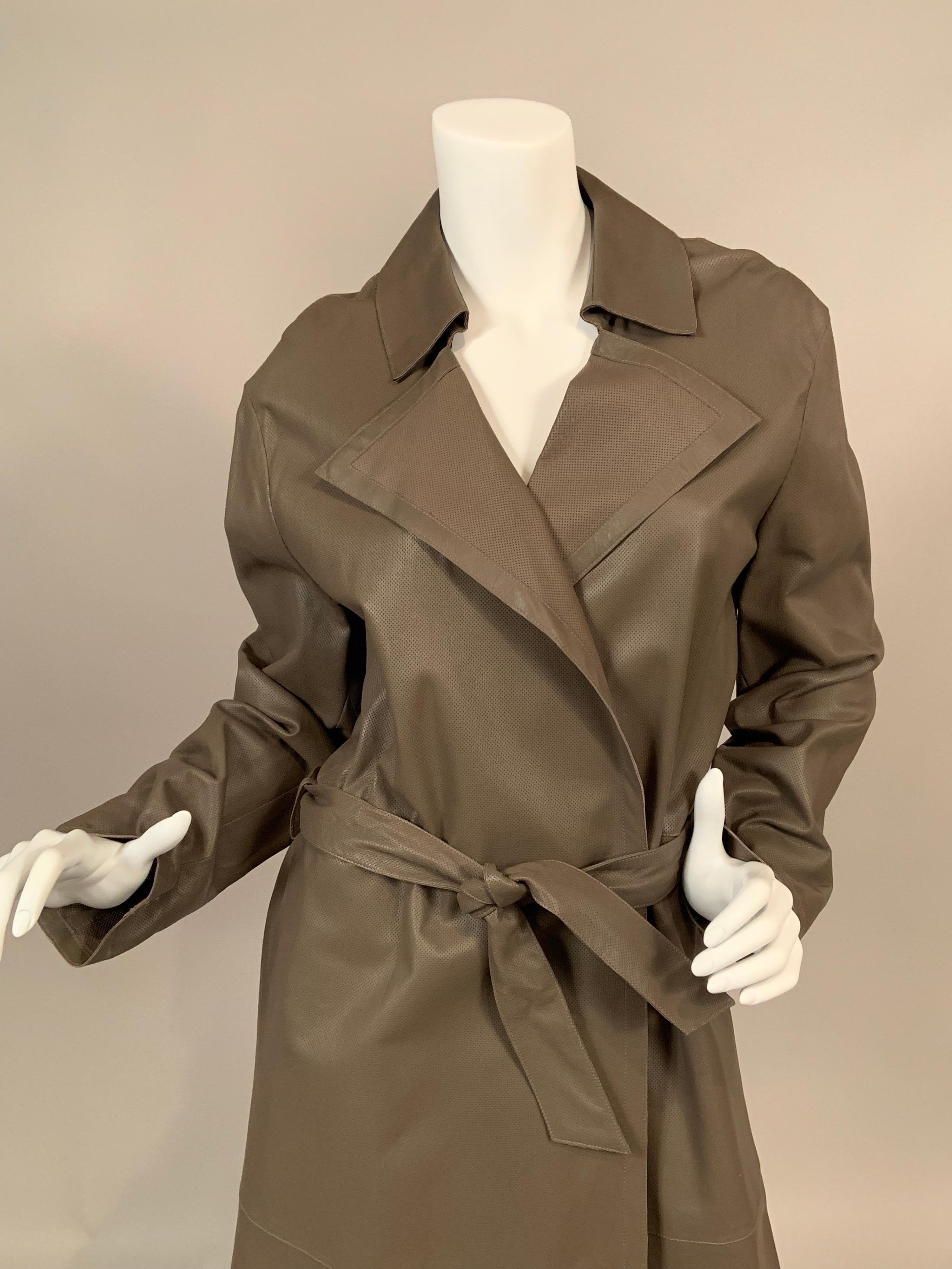 La forme et la couleur d'un trench-coat classique sont portées à un niveau de design supérieur avec de la peau d'agneau souple non doublée et perforée d'un motif.  de très, très petites perforations. Le manteau est doté de revers crantés, d'une