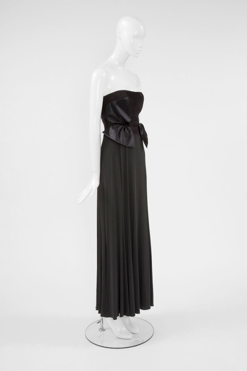 This alluring Giorgio Armani bustier gown is constructed of silk jersey in a refined blackish grey-brown. The flattering bustier is entirely pleated and features two oversized satin silk bows that, litteraly, seem to bloom out from the pleats. The