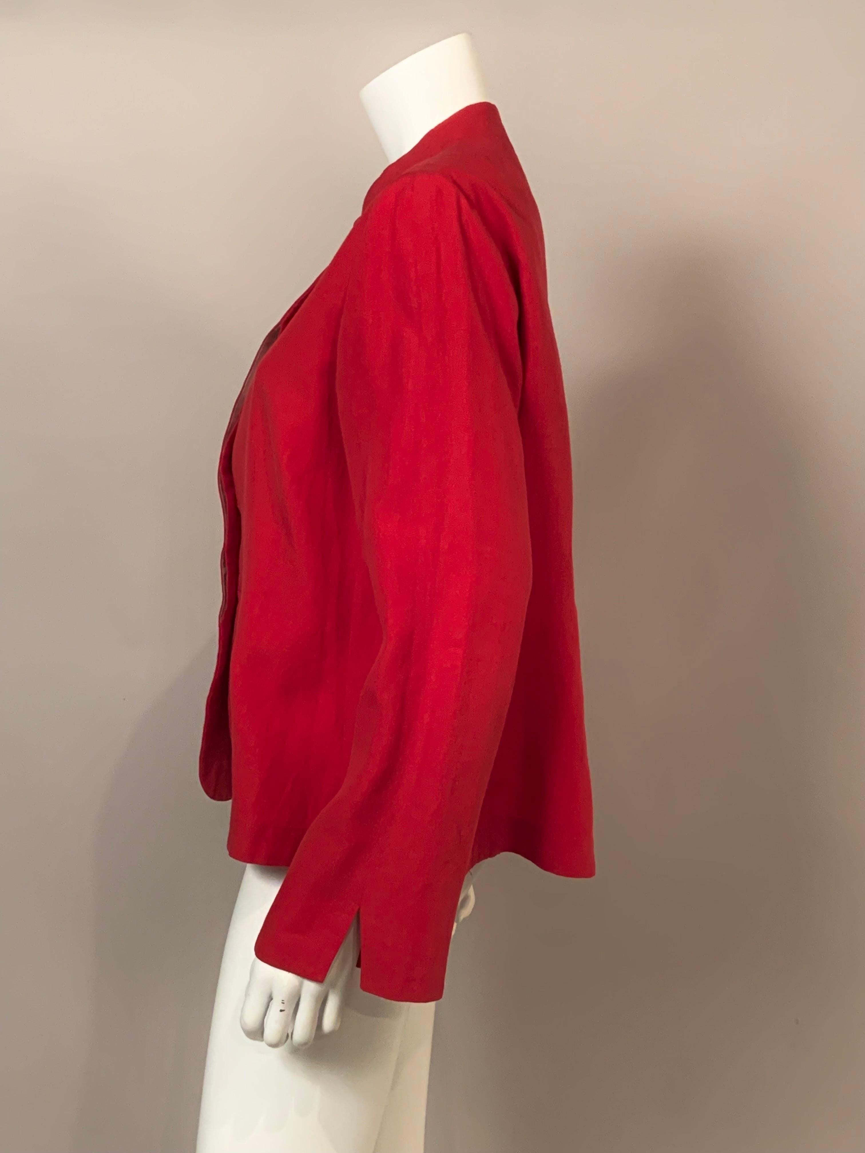 Giorgio Armani has designed this bright red linen jacket in the most classic and unadorned manner.  There is a Nehru style collar, hidden buttons at the center front inside a red and white striped button placket, which matches the partial lining in