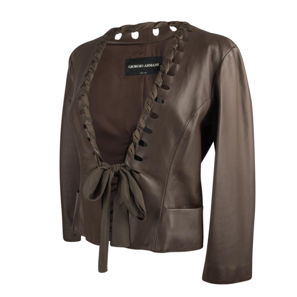 Giorgio Armani  exquisite leather jacket with unique details.
Rich deep taupe colour baby soft lamb leather.
Deep V neckline has matching ribbon woven around the open cut away.
The ribbon ties at the waist. 
2 Pockets.
The rear has an open inverted