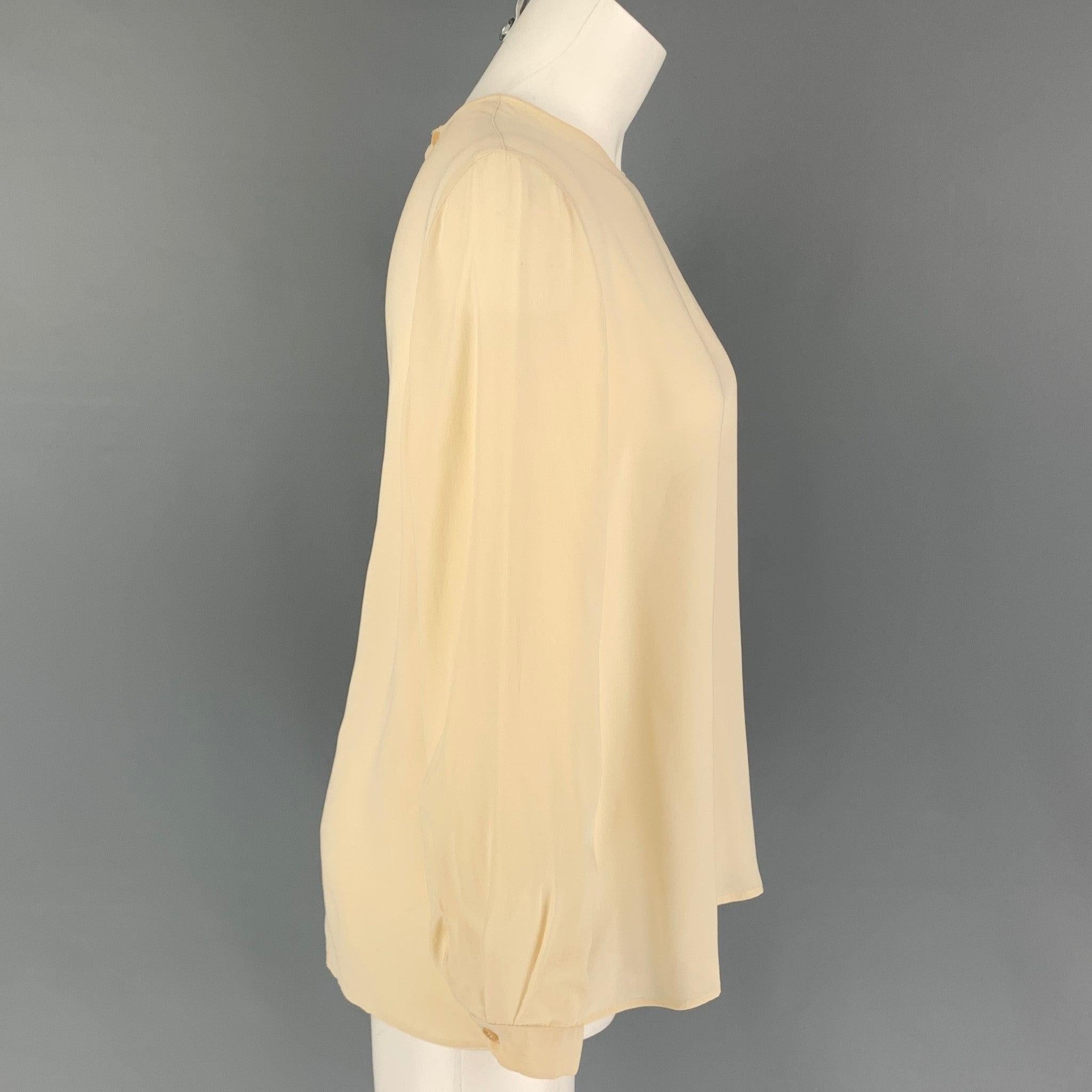 GIORGIO ARMANI blouse comes in a cream silk featuring a back buttoned closure.
Good
Pre-Owned Condition. Moderate discoloration at front & back.  

Marked:   46 

Measurements: 
 
Shoulder: 15 inches  Bust: 42 inches  Sleeve: 22.5 inches  Length: 25