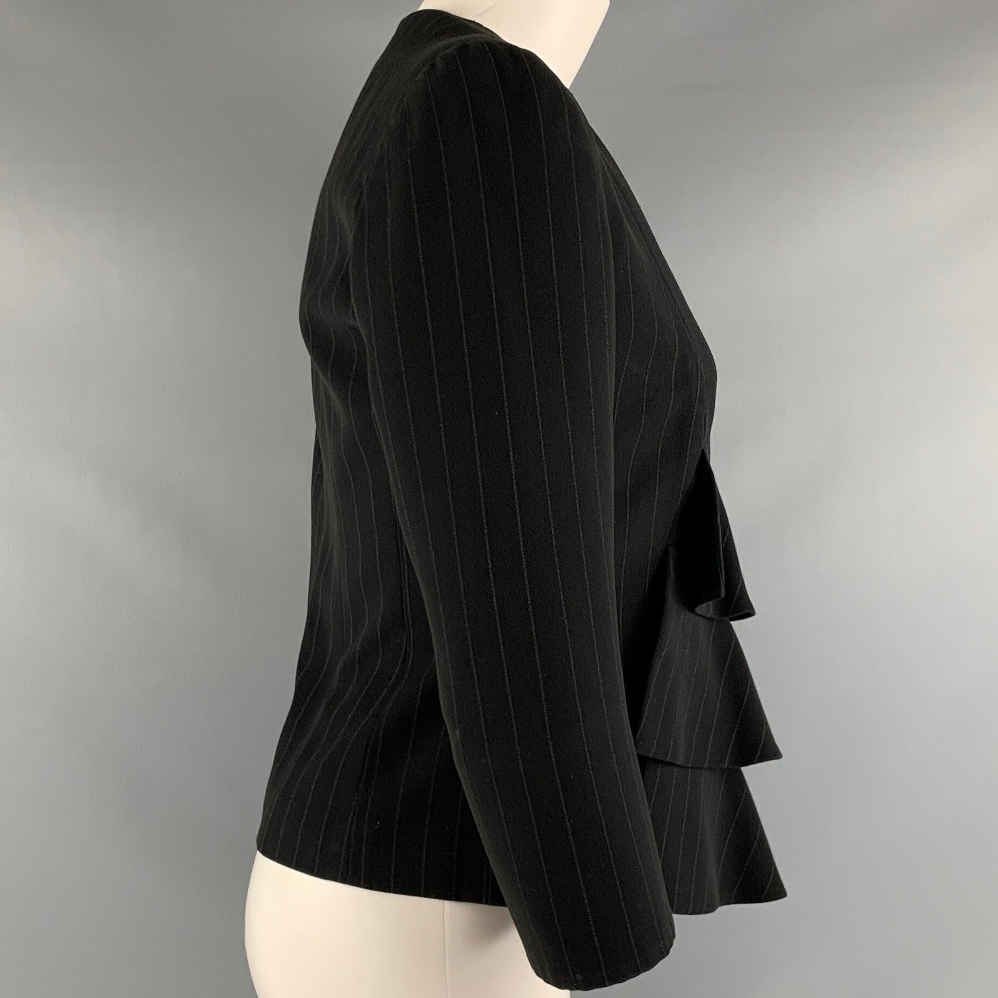 GIORGIO ARMANI
blazer in a black fabric featuring a ruffle front, pinstripe pattern, 3/4 sleeves, and snap button closure. Made in Italy.Very Good Pre-Owned Condition. Minor signs of wear. 

Marked:   38 

Measurements: 
 
Shoulder: 14 inches  Bust: