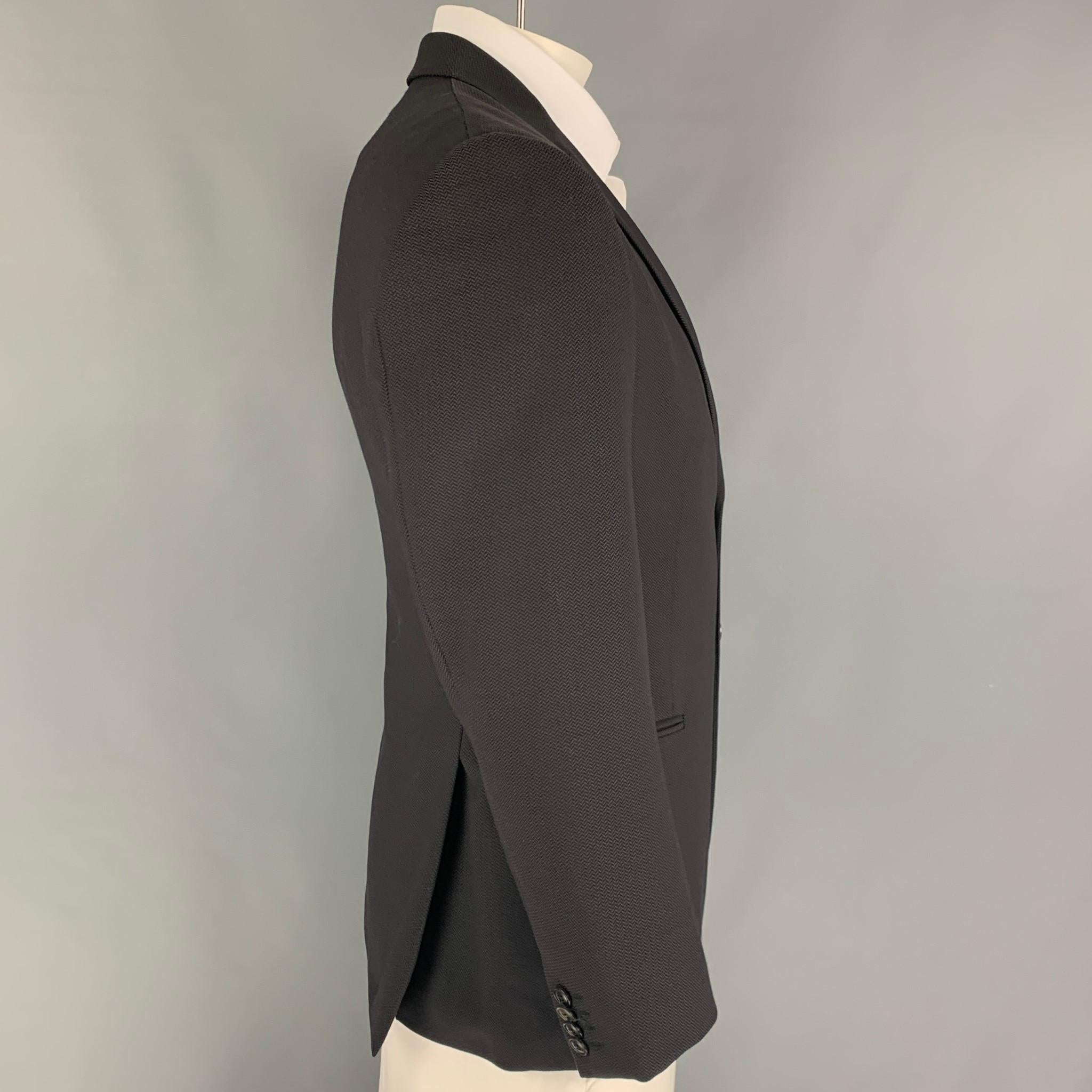 GIORGIO ARMANI sport coat comes in a black lana wool with a full liner featuring a notch lapel, slit pockets, double back vent, and a double button closure. Made in Italy.

Very Good Pre-Owned Condition.
Marked: 50

Measurements:

Shoulder: 18