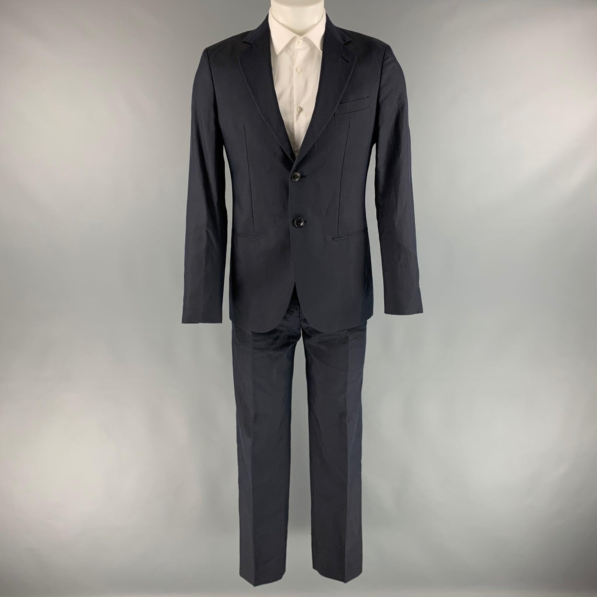 GIORGIO ARMANI Suit comes in a navy cotton silk woven material with a half liner and includes a single breasted, two button sport coat with a notch lapel and a matching flat front trousers. Made in Italy.Very Good Pre-Owned Condition.  

Marked:  