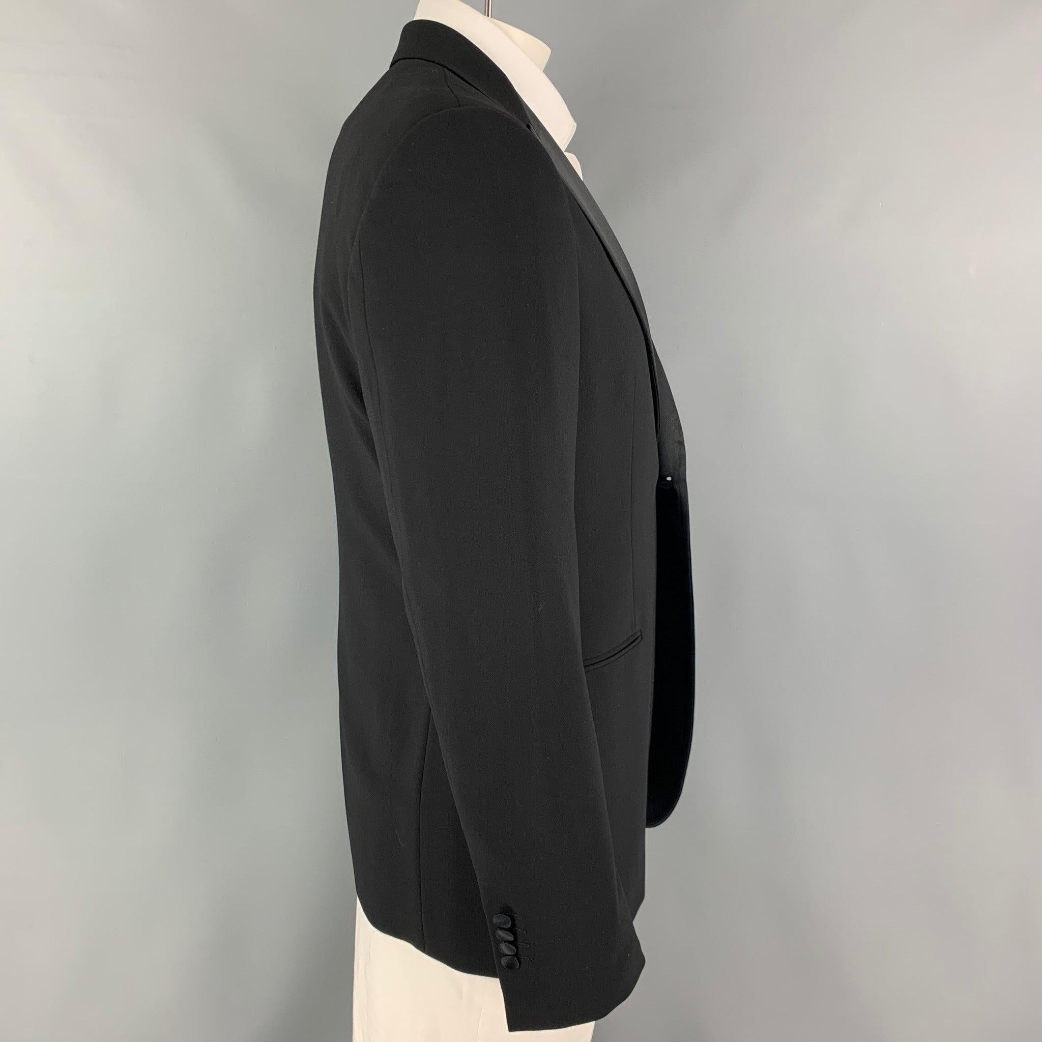 GIORGIO ARMANI sport coat comes in a black lana wool with a full liner featuring a peak lapel, slit pockets, and a single button closure. Made in Italy.
Very Good
Pre-Owned Condition. 

Marked:   52 

Measurements: 
 
Shoulder: 18 inches Chest:
42