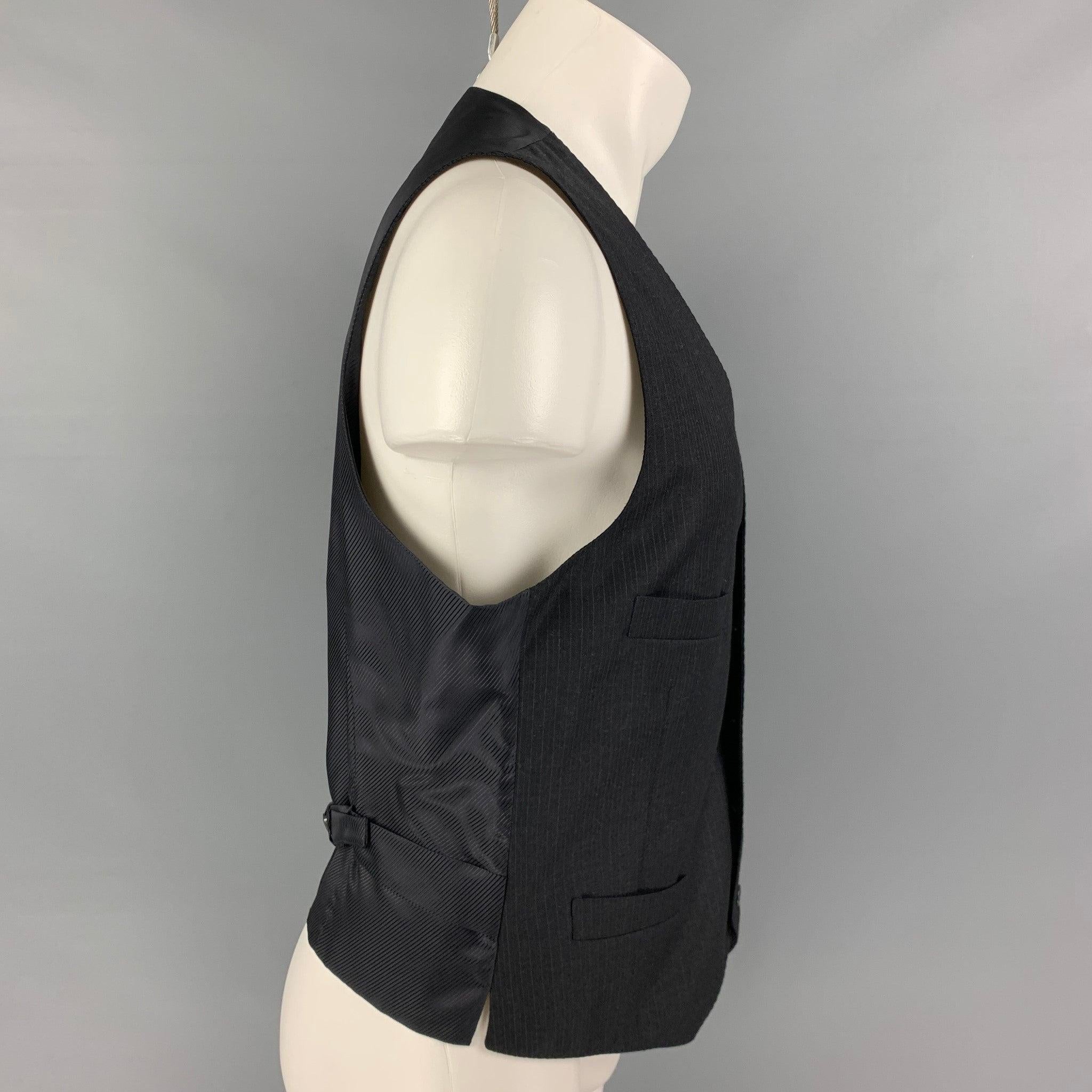 GIORGIO ARMANI vest comes in a charcoal pinstripe wool featuring a adjustable back, slit pockets, and a buttoned closure. Made in Italy.
Excellent
Pre-Owned Condition. 

Marked:   52 

Measurements: 
 
Shoulder: 13.5 inches  Chest: 40 inches Length: