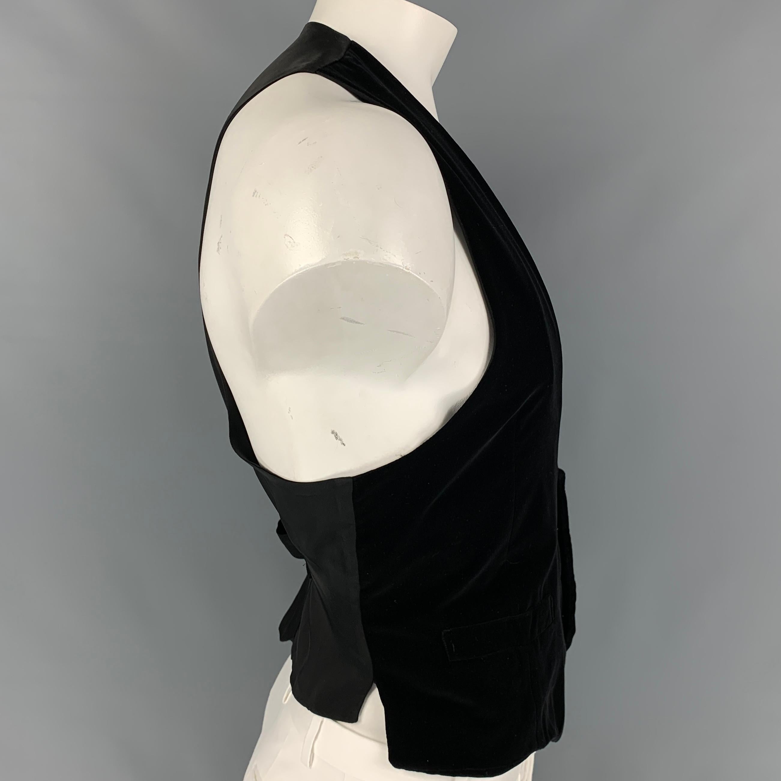 GIORGIO ARMANI vest comes in a black velvet cotton / silk featuring a deep v-neck, back belt, slit pockets, and a buttoned closure. Made in Italy. 

Very Good Pre-Owned Condition.
Marked: 56/46

Measurements:

Shoulder: 13 in.
Chest: 42 in.
Length: