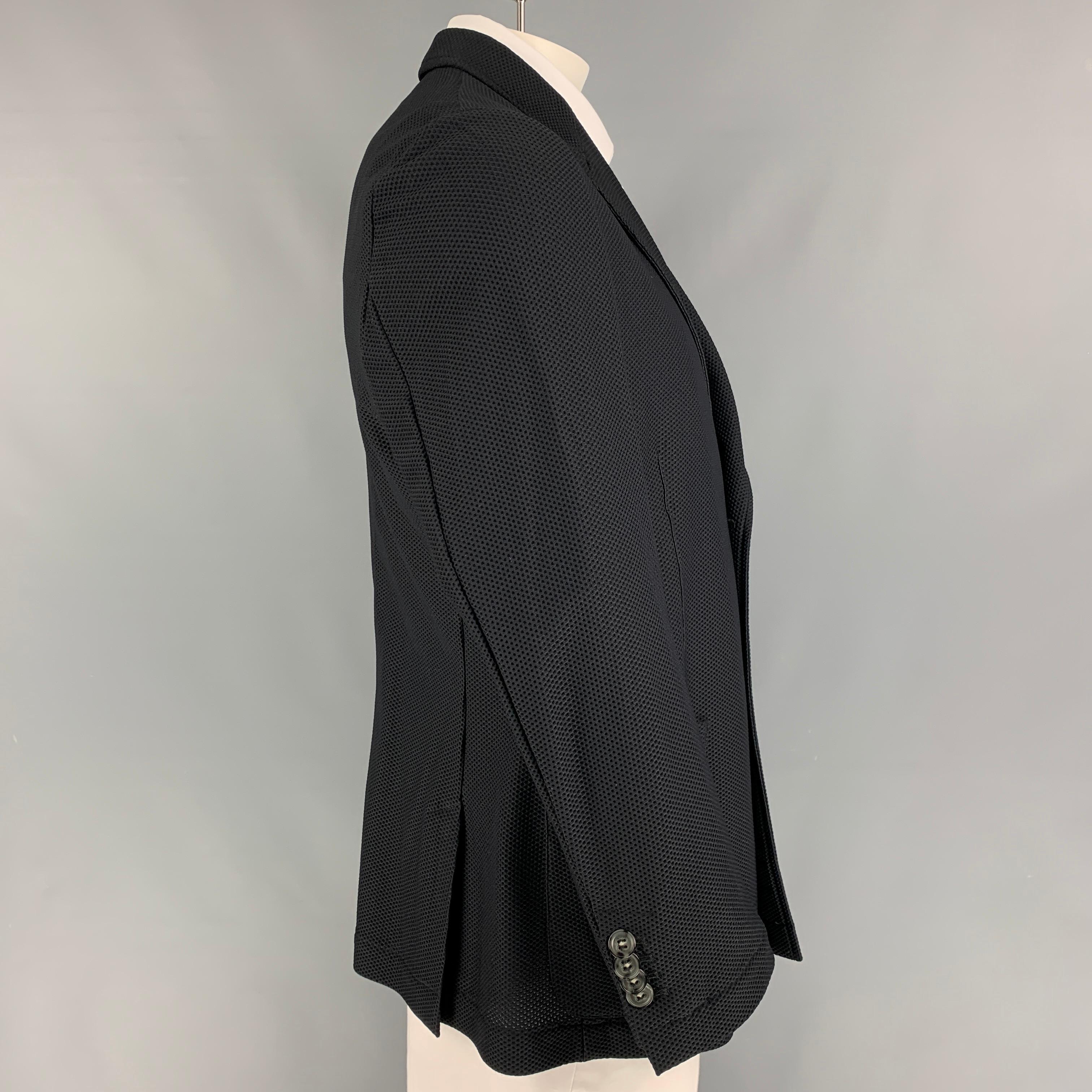 GIORGIO ARMANI sport coat comes in a black waffle knit polyamide with a half liner featuring a peak lapel, patch pockets, double back vent, and a double breasted closure. Made in Italy. 

Very Good Pre-Owned Condition.
Marked: