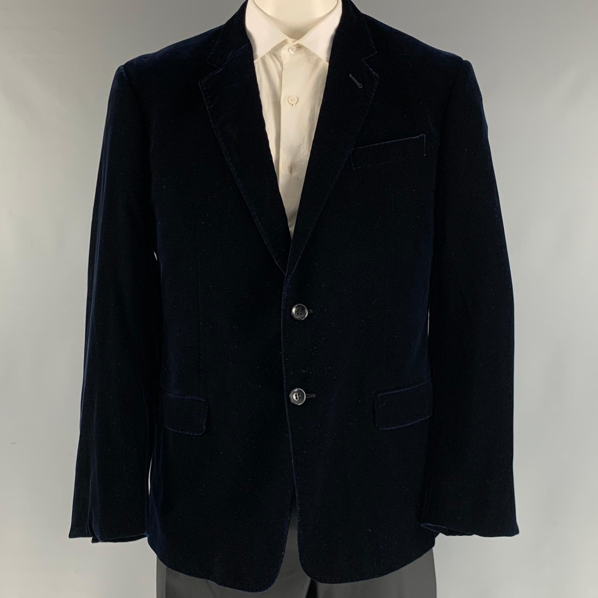 EMPORIO ARMANI 'Soft' sport coat comes in navy velvet viscose blend material with full liner featuring a notch lapel, patch pockets, and a two button closure. Made in Italy.

Excellent Pre-Owned Condition.
Marked: 56R

Measurements:

Shoulder: 20