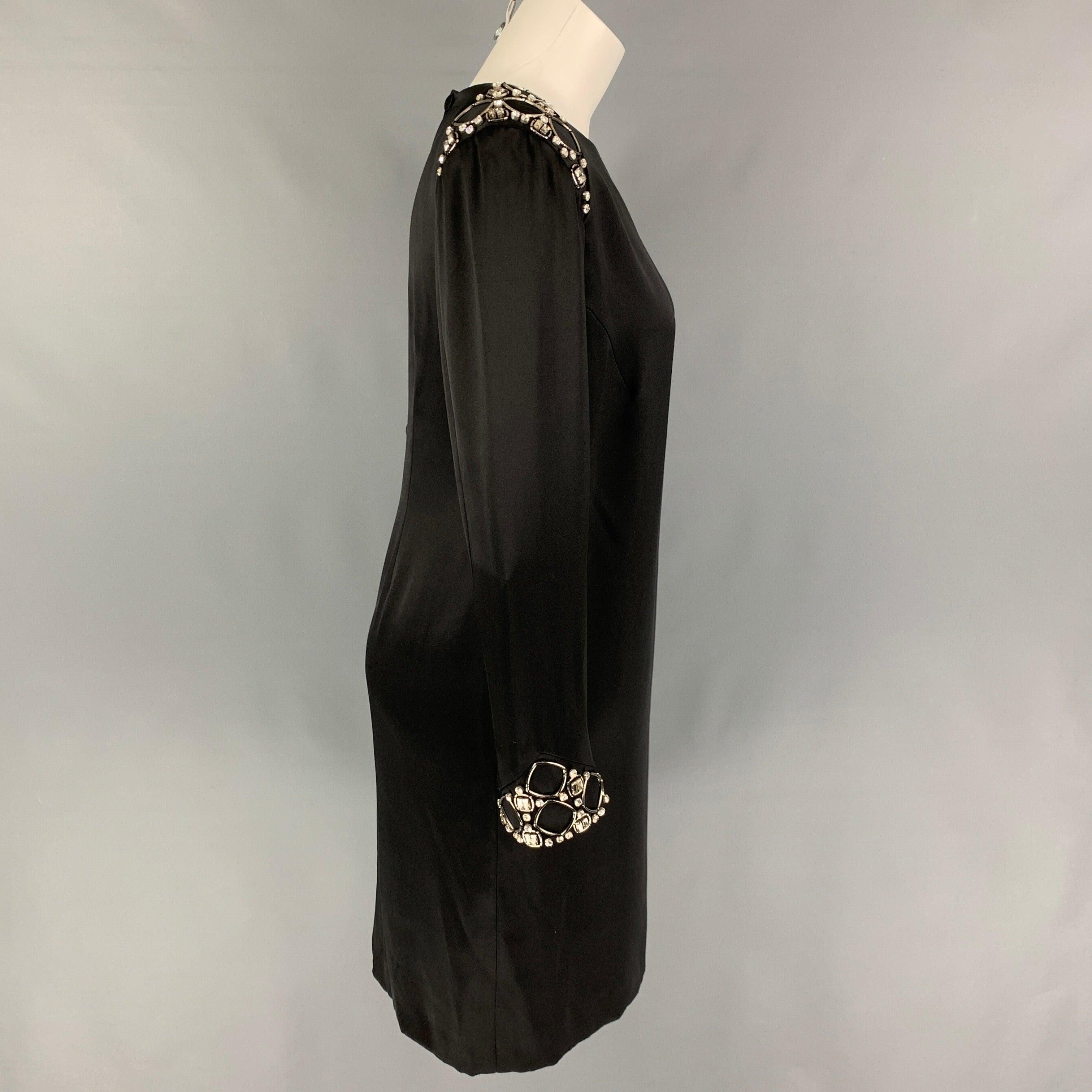 GIORGIO ARMANI dress comes in a black silk featuring a sheath style, crystal embellishments, slit pockets, shoulder pads, and a back buttoned closure. Made in Italy.
Very Good
Pre-Owned Condition. 

Marked:   42 

Measurements: 
 
Shoulder: 16