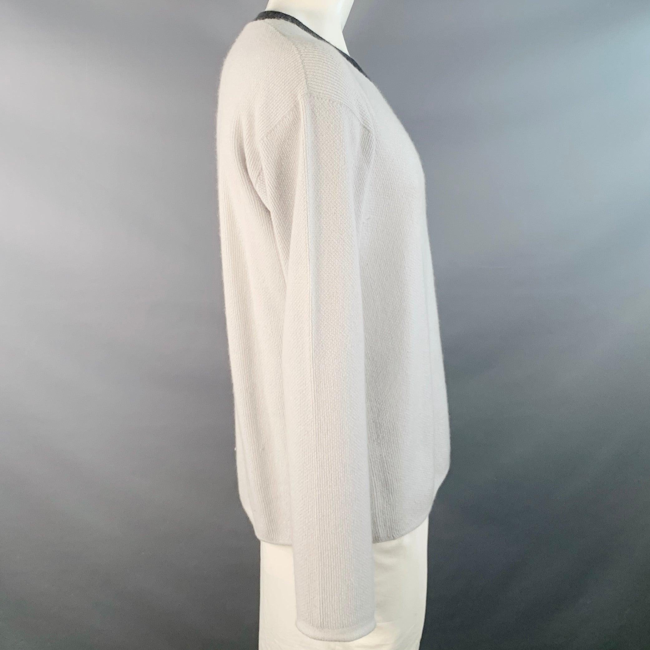 Pull GIORGIO ARMANI
en maille de soie de cachemire gris clair, manches longues, col en V et bordures gris anthracite. Fabriqué en Italie. Bon état d'usage. Boulochage modéré et signes d'usure. 

Marqué :   IT 54 

Mesures : 
 
Épaule : 23 pouces
