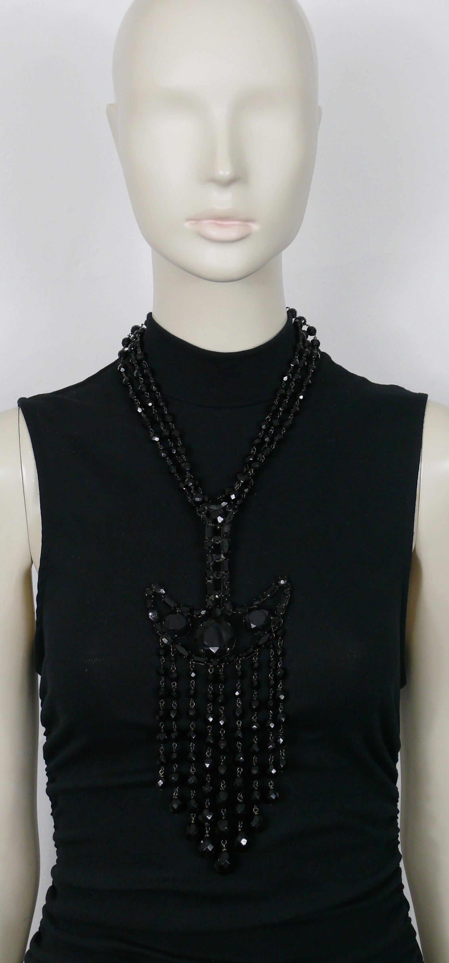 Collier tendance GIORGIO ARMANI composé de perles noires de jais.

Ferrures en métal patiné.

Peut être porté comme une broche (il y a du poids dessus !).

Fermeture réglable avec fermoir en forme de homard.

Gaufrage GIORGIO ARMANI.

Mesures