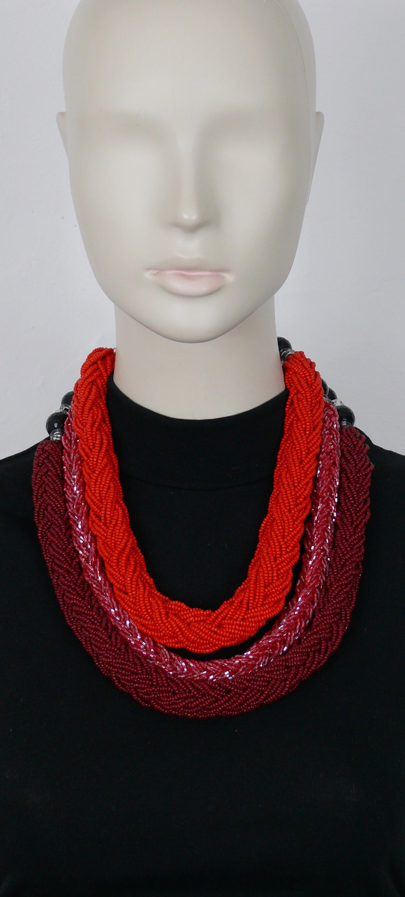 GIORGIO ARMANI statement necklace meade of three strands of braided baids in shades of red, black resin facetted beads and clear resin rondelles.

T-bar and toggle closure.

Embossed with the GA monogram.

Indicative measurements : length approx. 56