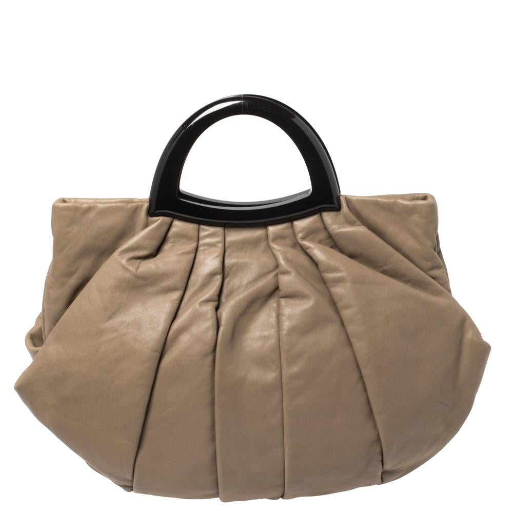 Be ready to catch admiring glances when you carry this stunning taupe-hued bag from Giorgio Armani. Crafted from quality leather the bag comes with a pleated exterior, a top handle, and a spacious fabric-lined interior. It is finished with