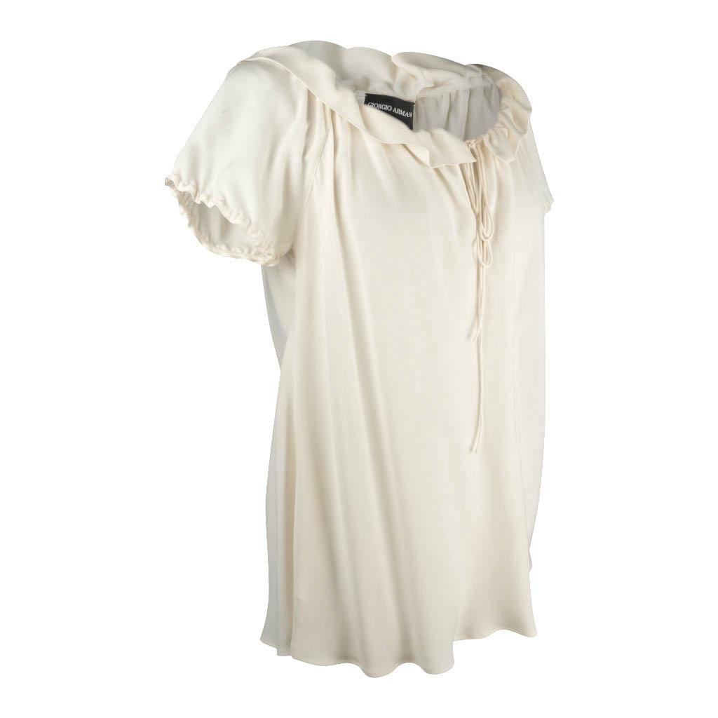 Guaranteed authentic Giorgio Armani top features winter white silk.
Gently ruffled drawstring neckline. 
Short sleeves edged with small ruffles.
Charming and versatile.
NEW or NEVER WORN.  Tag attached.

SIZE 46
USA SIZE 10

TOP MEASURES: 
LENGTH
