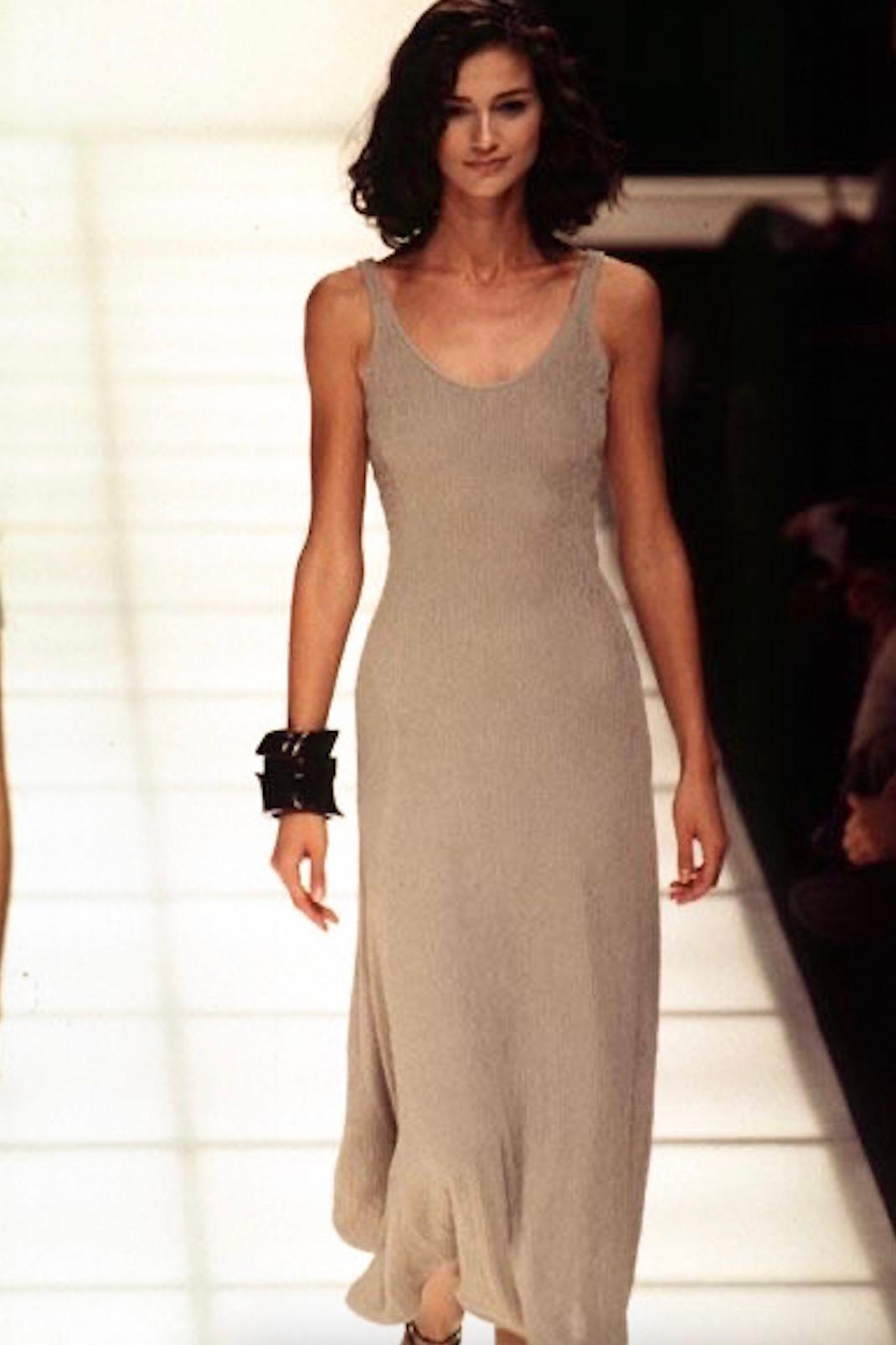 This exquisite vintage 1990s Giorgio Armani dress is a stunning example of timeless elegance. Crafted in Italy, this sleeveless beige maxi dress is intricately embellished with delicate beading throughout, giving it a subtle shimmer. The deep scoop