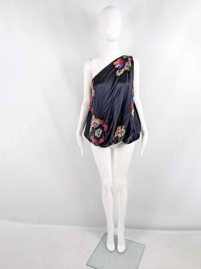 A glamorous vintage womens blouse from the 2000s by luxury Italian designer, Giorgio Armani. Made in Italy, from a navy blue pure silk satin with an arty floral print throughout. It has a loose, bubble / blouson style fit and a one shouldered