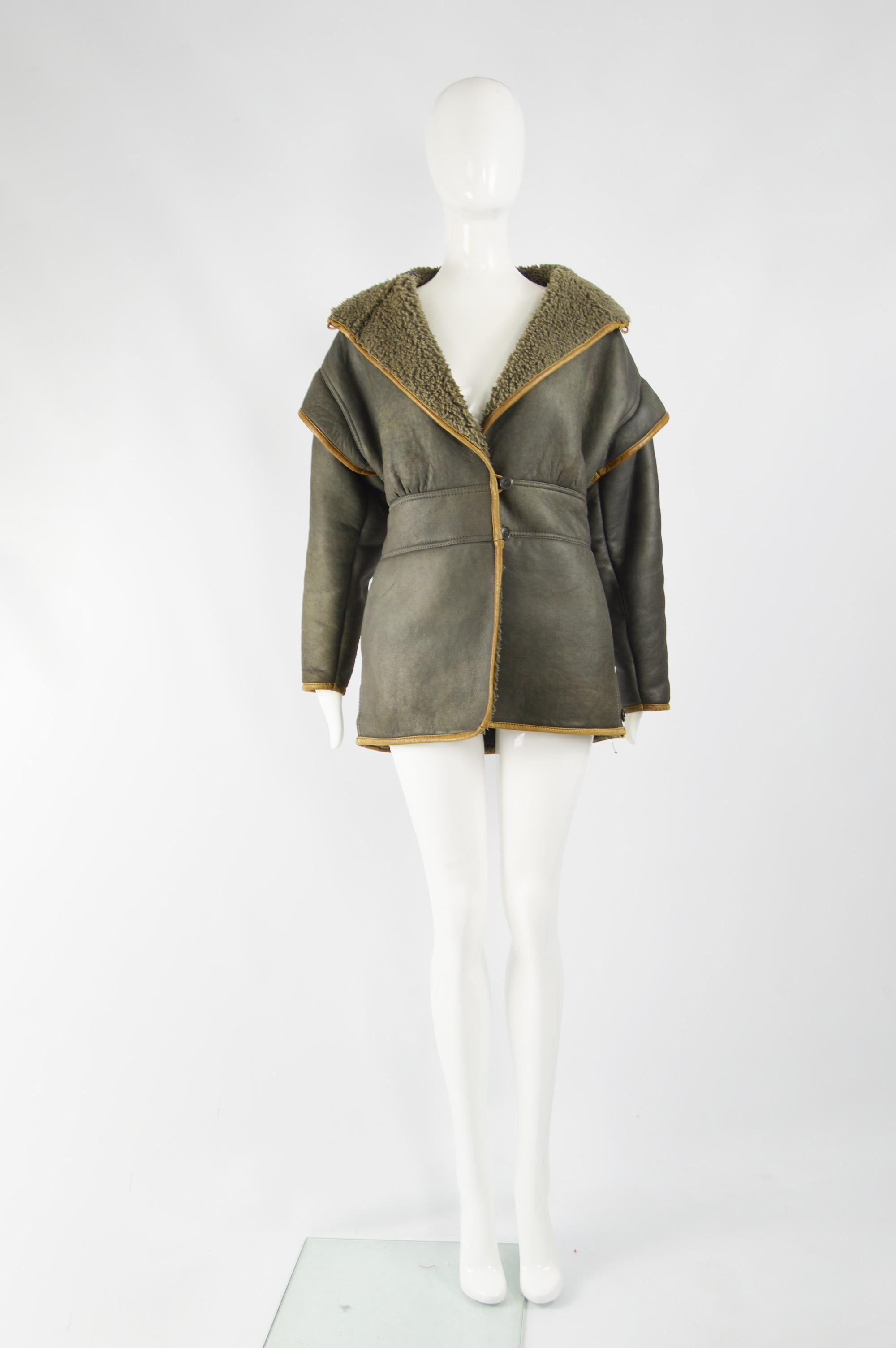 An amazing and rare vintage womens Giorgio Armani jacket from the 80s. In a grey shearling / sheepskin and leather trim. It has an architectural shape with shoulder caps, a nipped waist and blouson fit on top. 

Size: Marked IT 40 but fits more like