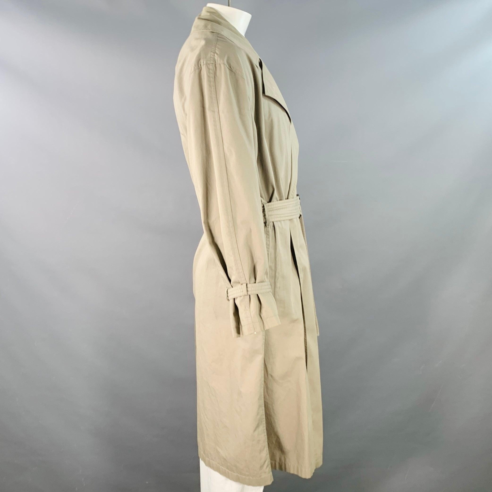 Trench vintage di Giorgio Armani
in tessuto di cotone color kaki, con tasche a filetto, maniche lunghe e parte anteriore aperta con cintura. Moderati segni di usura, così com'è. 

Contrassegnato:   42 

Misure: 
 
Spalla: 20,5 pollici Petto: 54