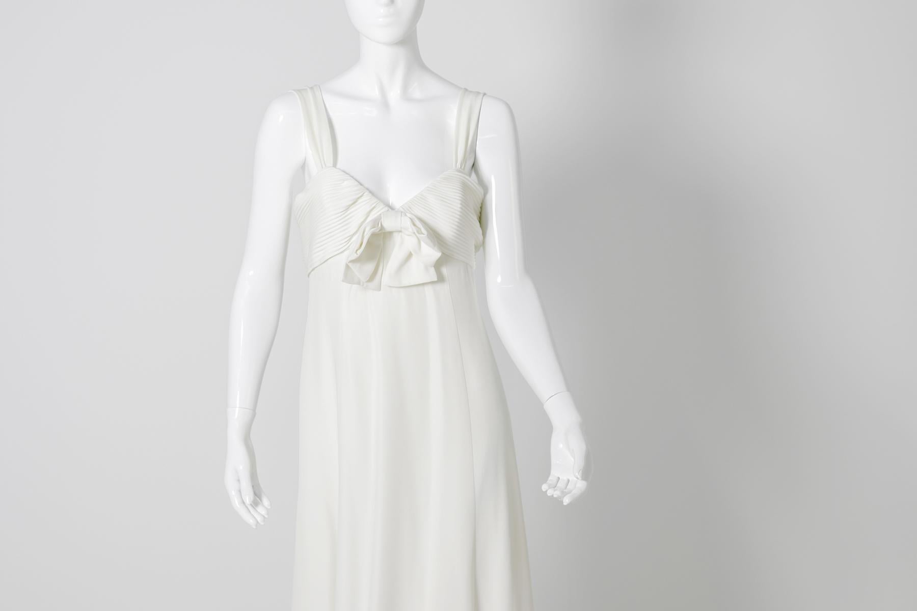 Wonderful and essential wedding dress by Giorgio Armani Collezioni from 2008. The dress is made of silk and white acetate. It is characterized by a deep V neckline. To give more strength to the neckline is its weave with bow . Its shoulder straps