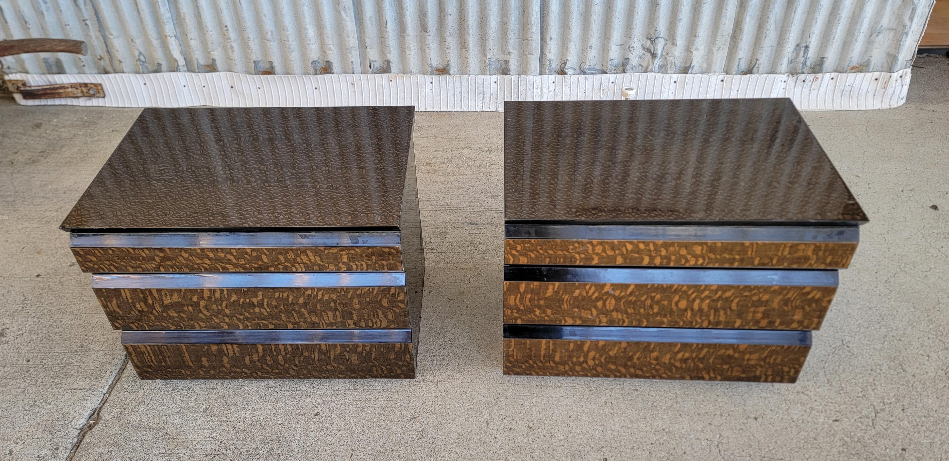 A pair of Giorgio Collection nightstands or end tables with snakewood and black lacquer finish. Each features 3 drawers on metal glides. Retaining 