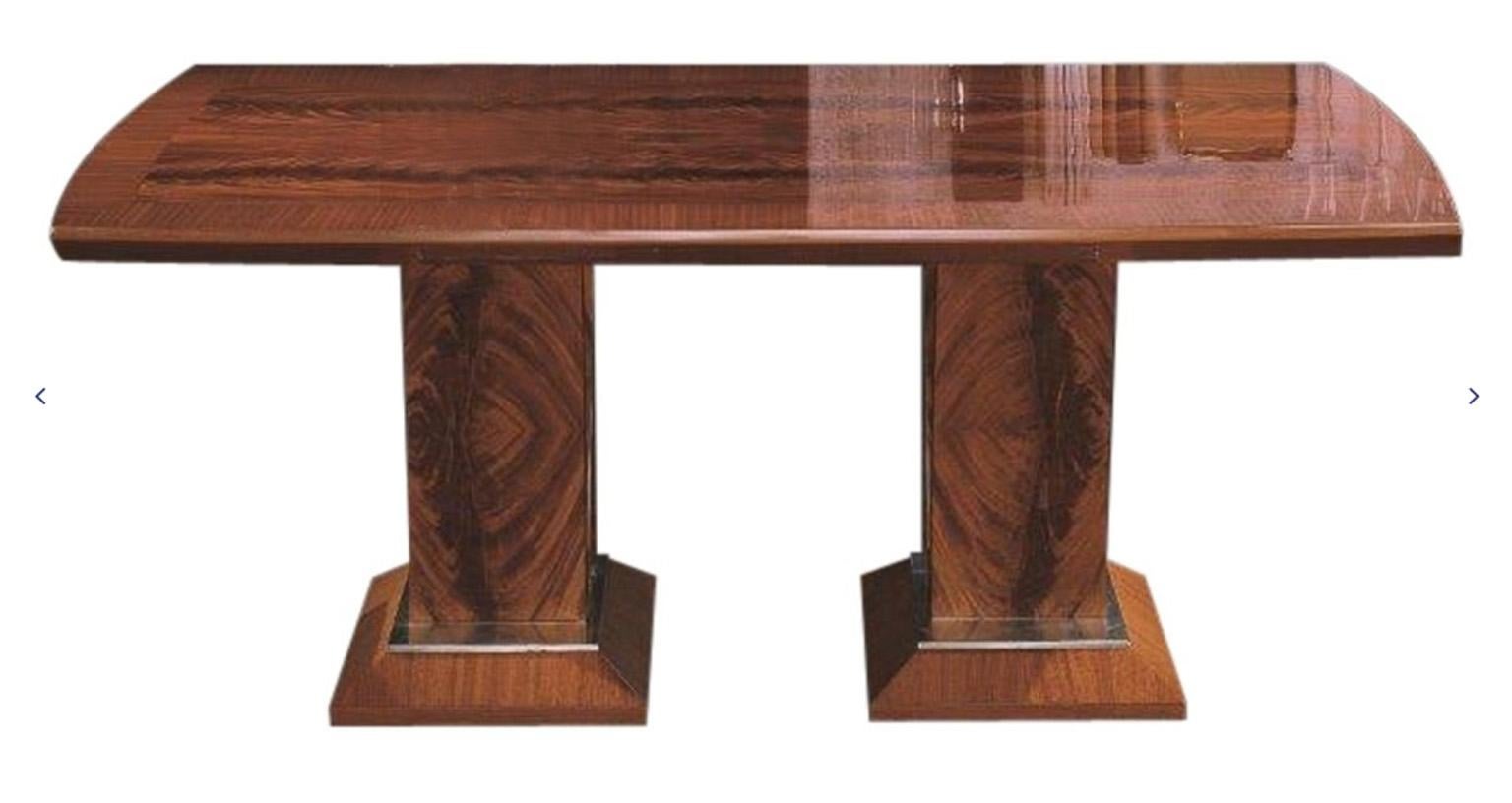 Rechteckiger Tisch in Bootsform mit zwei Verlängerungsplatten.
Decke aus einer Kombination von Mahagoni und geradem Sapelimahagoni.
Details aus gebürstetem Stahl am Sockel.
Offener Tisch: 112