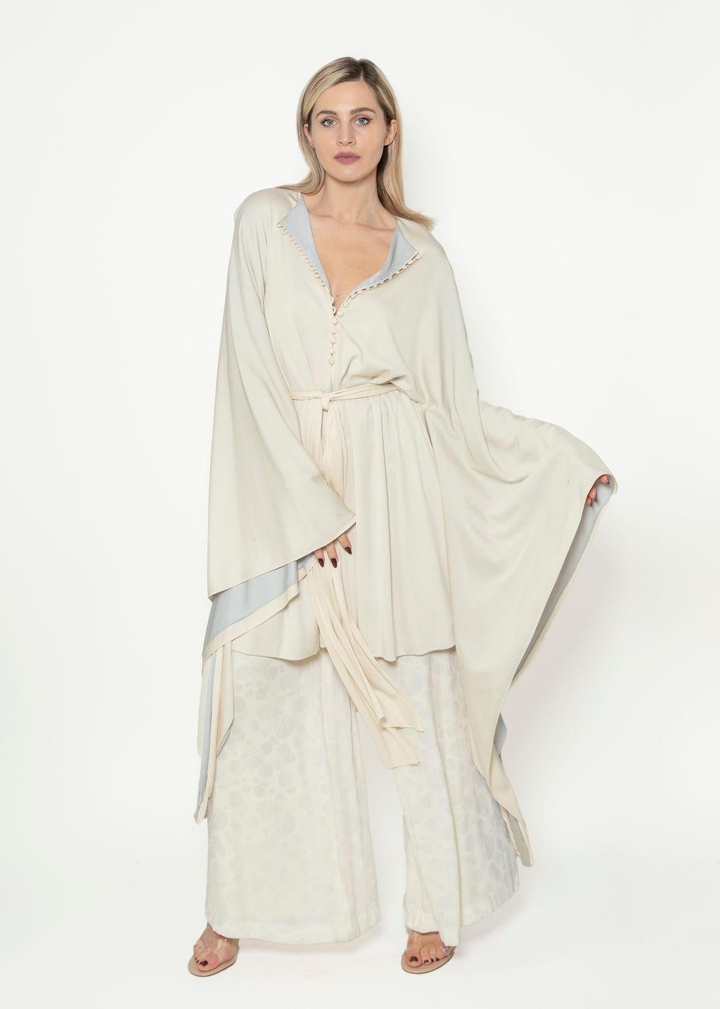 Our Documented 1974 Giorgio Di Sant Angelo Taupe Angel Sleeve Belted Dress is sure to command the eyes of everyone in the room!

It features very large double layered Angel sleeves.  Perfect to style as a dress or jacket, the piece does not fully