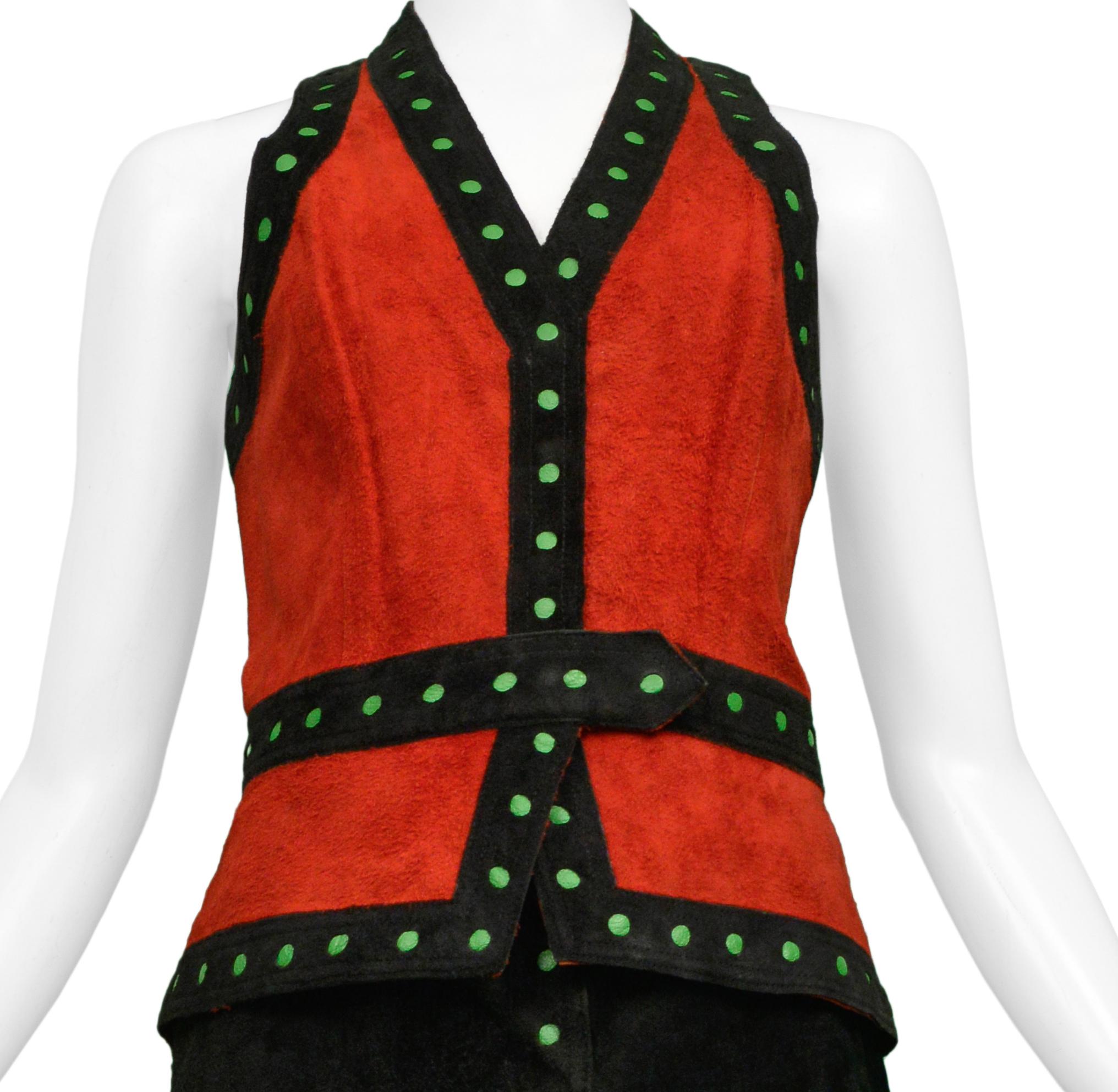 Resurrection Vintage a le plaisir de vous proposer un ensemble veste et jupe vintage en daim noir et rouge Giorgio Sant Angelo comprenant une veste rouge avec une bordure de points noirs et verts, et une jupe longue enveloppante en daim noir avec