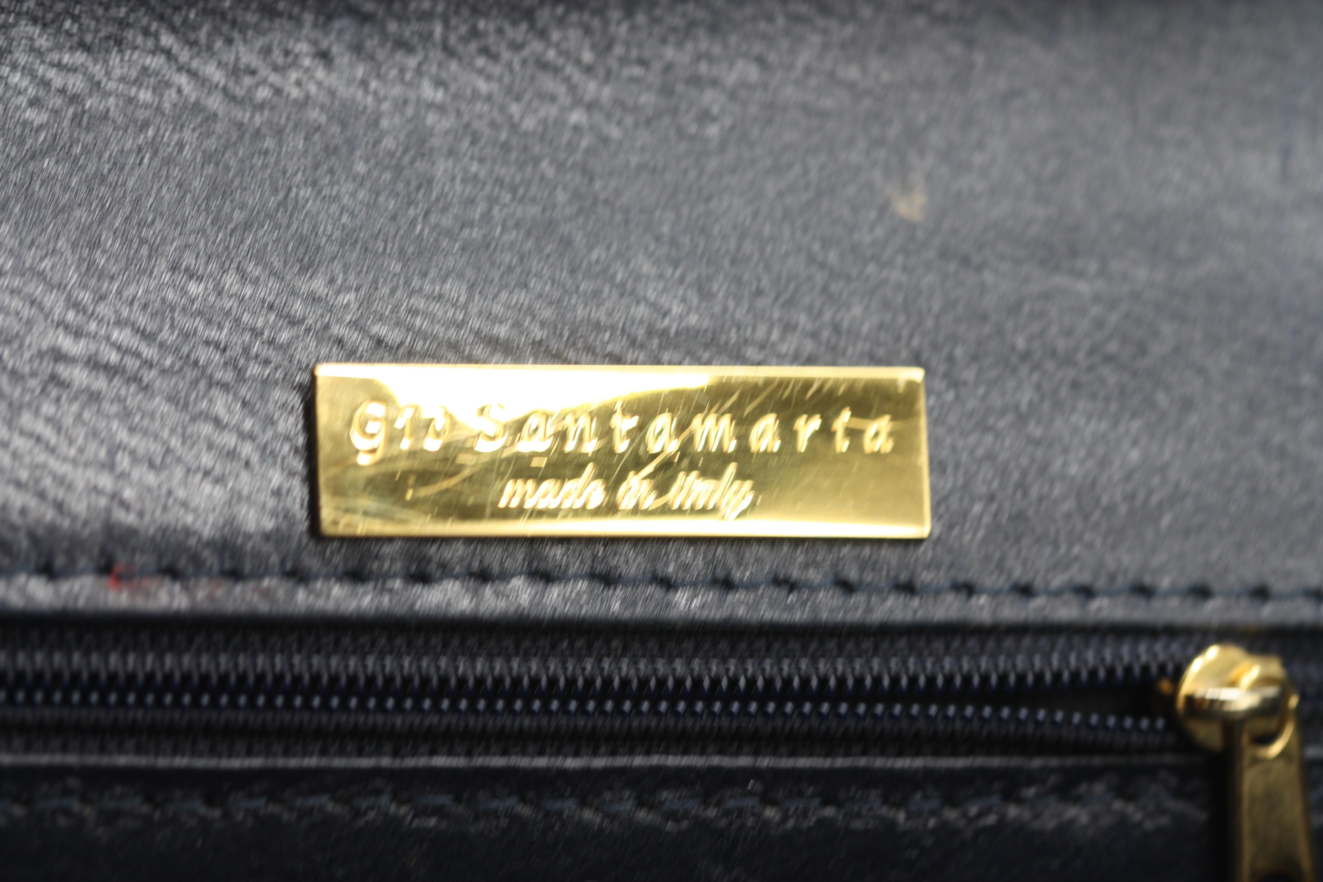 Bolso de aligátor azul oscuro Giorgio Santamaria

Exquisitamente elaborado en aligátor azul oscuro, este elegante bolso de mano rectangular ejemplifica el refinado lujo italiano. El diseño presenta una silueta estructurada con una solapa perfilada y