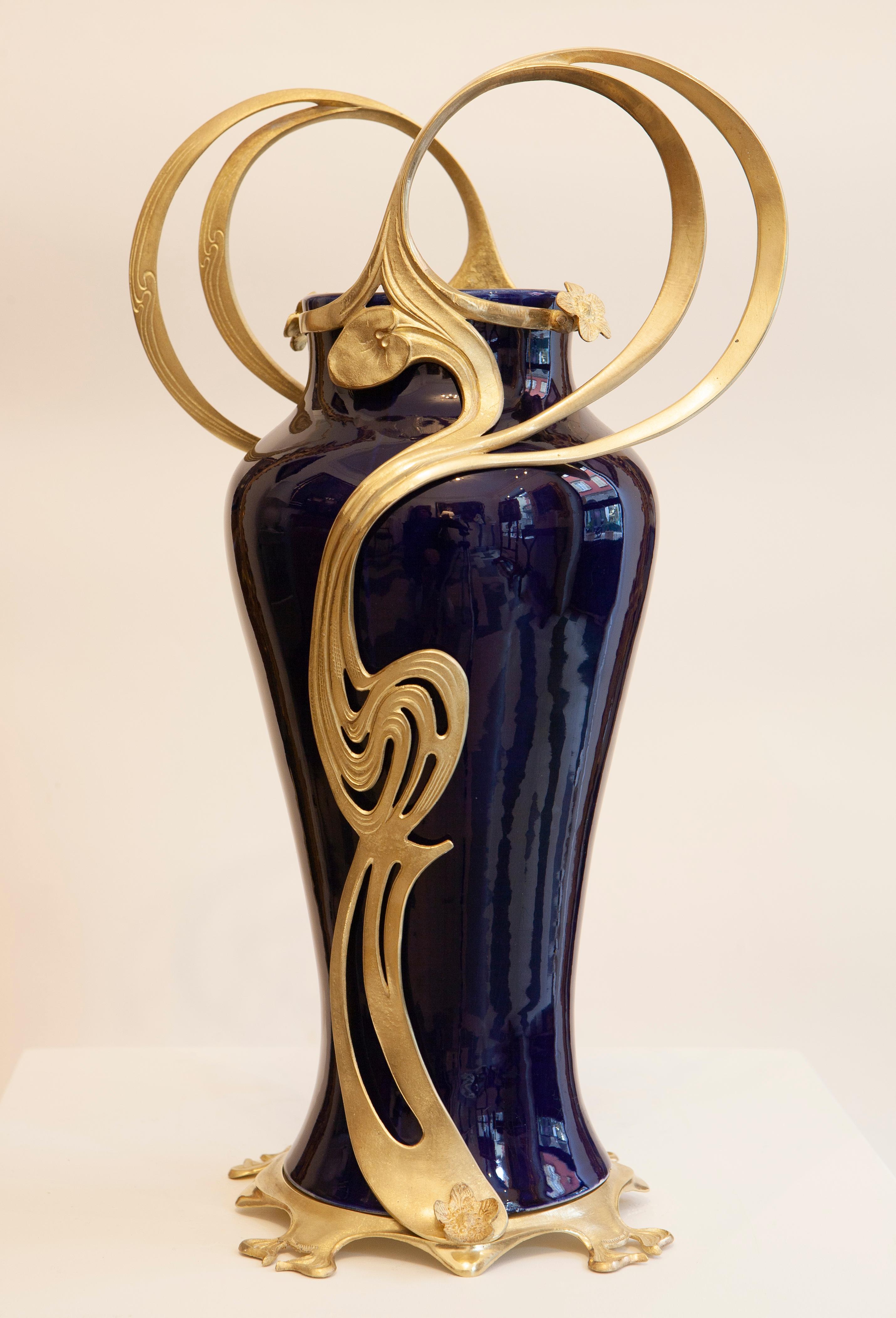 Giorgio Spertini (1877-1908)
Ceramic amphora vase decorated with blue glaze. Gold-plated brass frame with whip-line pattern with applied flowers. Made for Italian Ceramic Company Laveno (1856-1965)

Epoch: 1903
Materials: ceramic and gold-plated