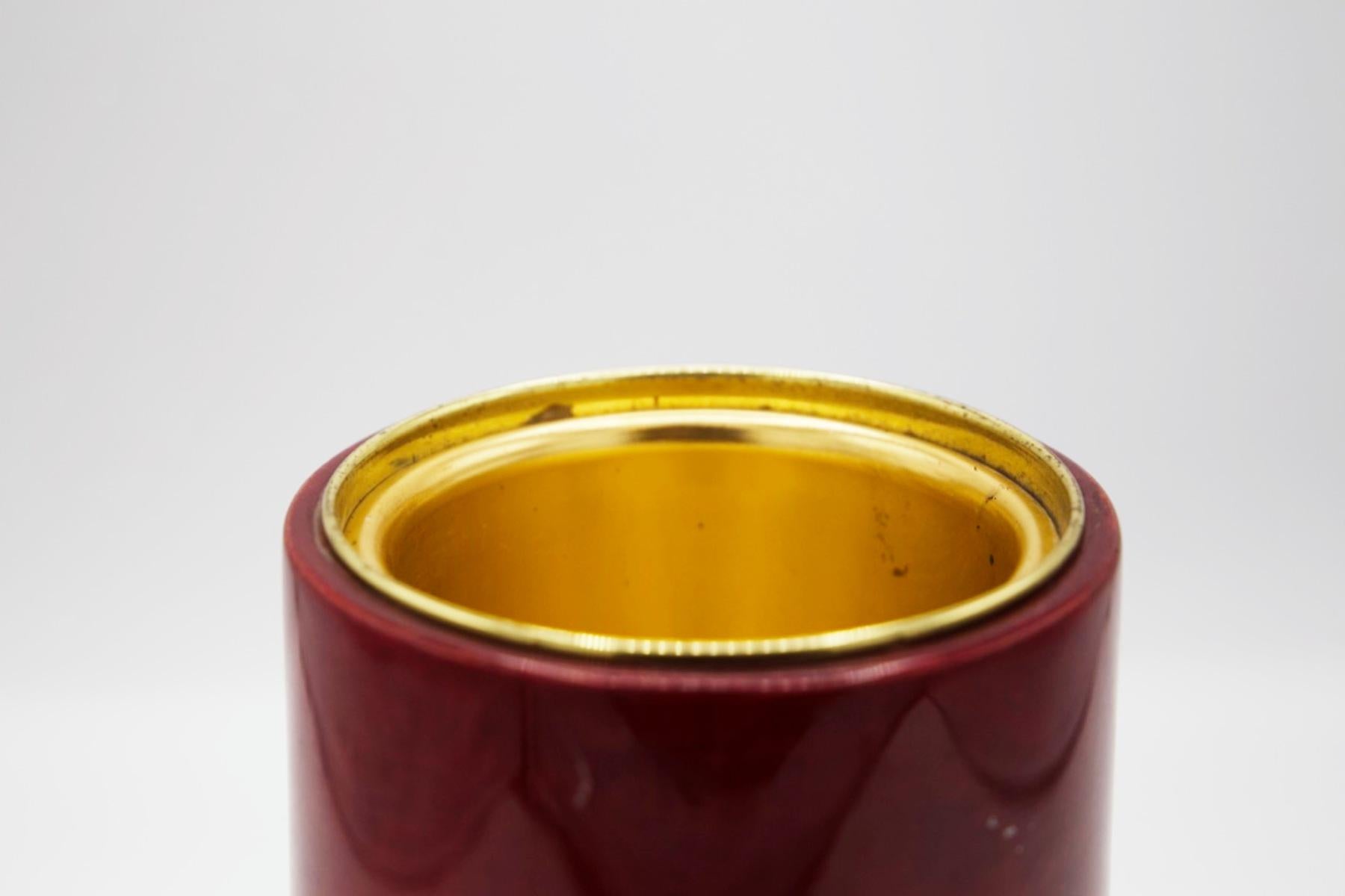 Beautiful beverage and ice holder made by Giorgio Tura in the 1950s.
Entirely made of red parchment on the outside, with a wider cylindrical base. The inside is gilded and can accommodate ice to allow drinks to be kept cold!