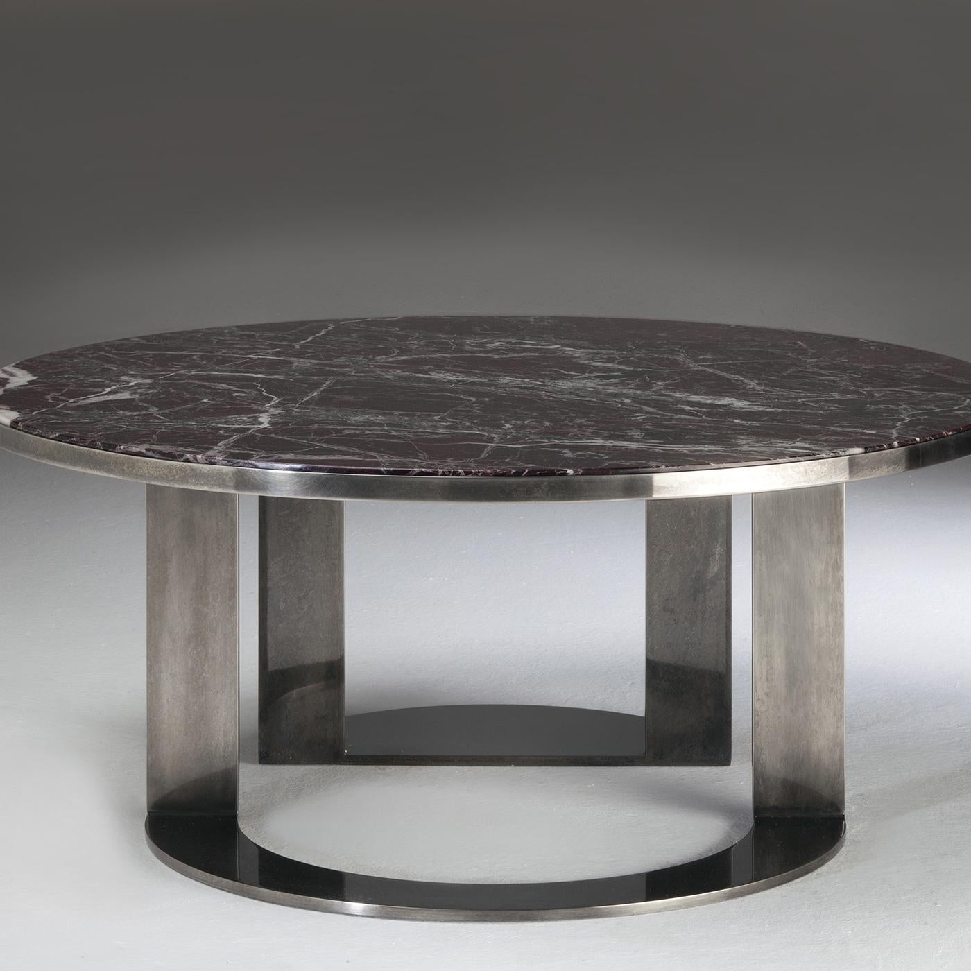 Designed by Luciano Pasut, this exquisite coffee table features an interplay of volumes and void created by the round top in Rosso Levanto marble mounted in a structure supported by asymmetrical cutout base in brushed and polished steel with a