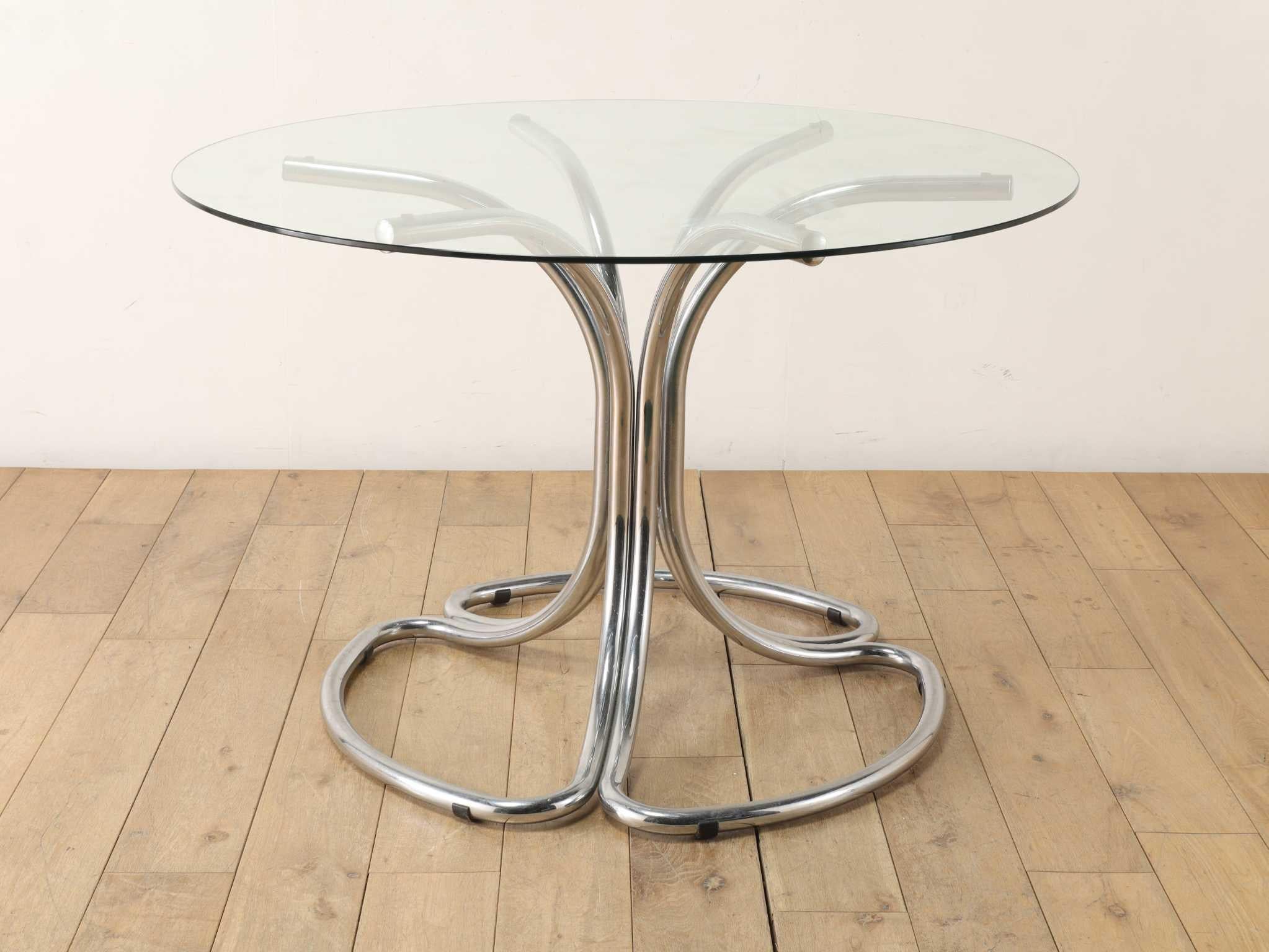 Cette étonnante table à plateau de verre est une création du célèbre designer italien Giotto Stoppino, célébré pour son approche audacieuse et avant-gardiste du design moderne.
La base métallique distinctive de la table sert à la fois de structure