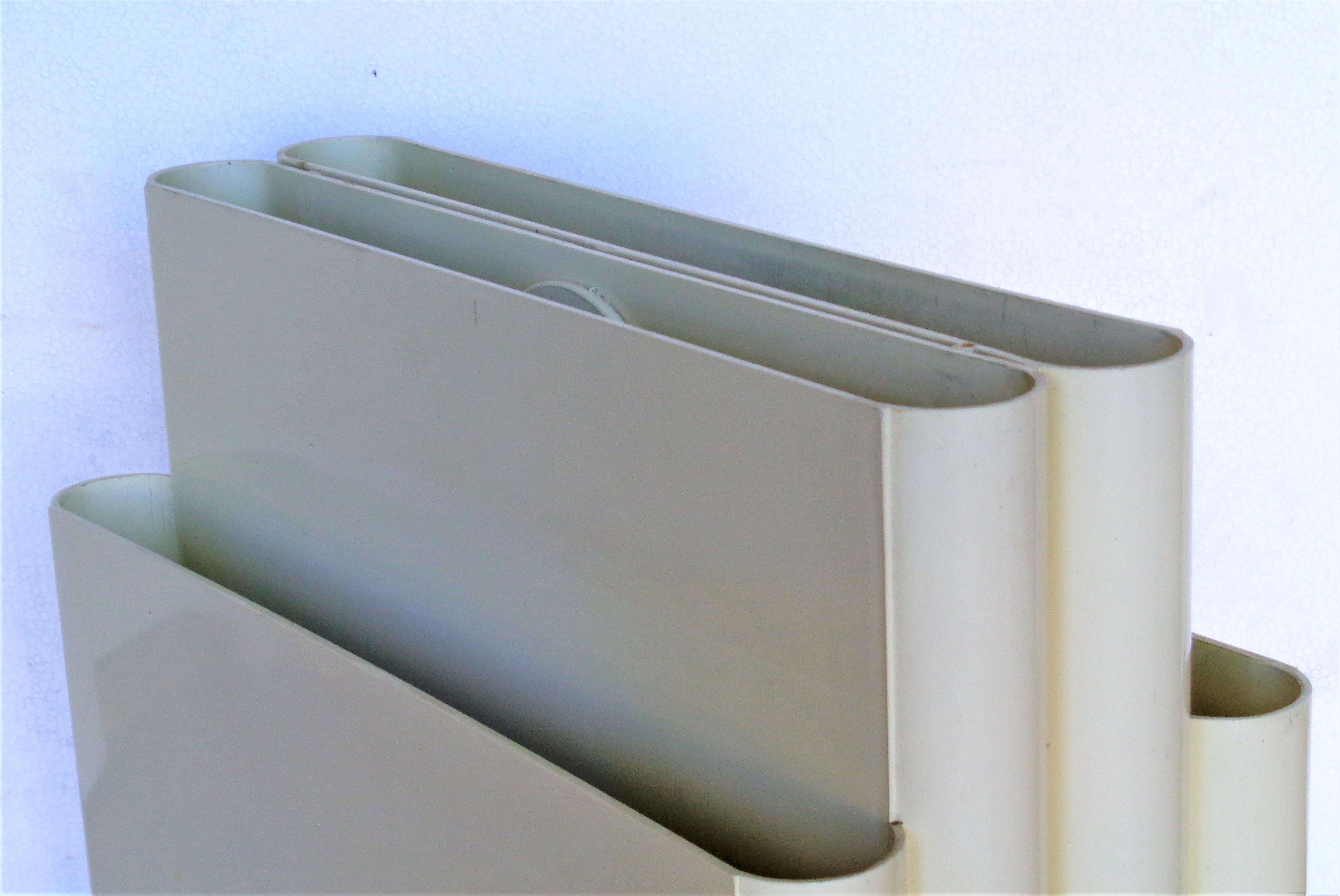 Iconic four slot cream white plastic magazine rack designed by Giotto Stoppino for Kartell with central circular handle for easy transport. Italy, circa 1970. Twice signed at underside bottom ( Kartell - Designer: Giotto Stoppino - 4676 - see img.