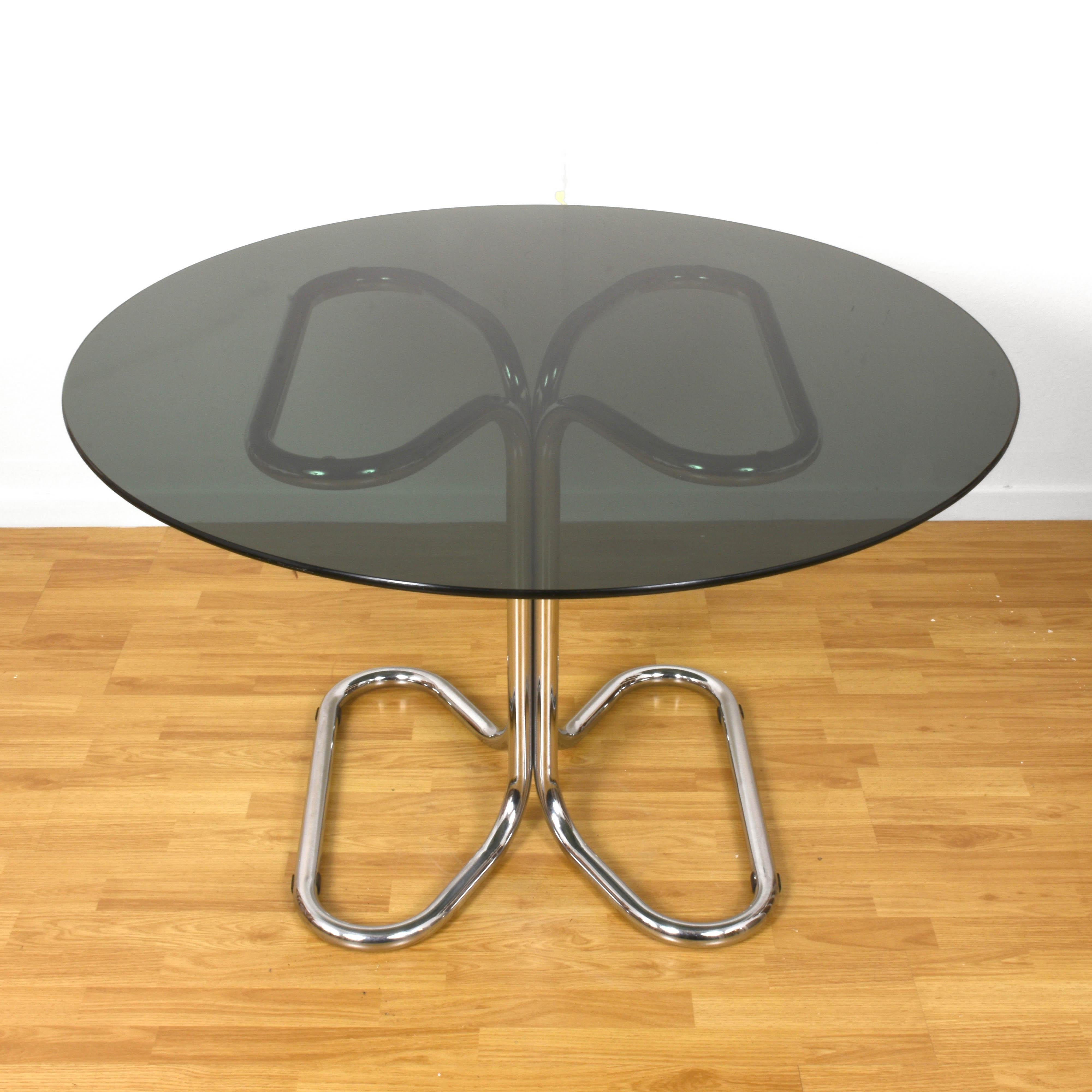 Midcentury chrome base and smoked glass top dining table. This marvellous dining table was designed by Giotto Stoppino in Italy during 1970s.

This amazing piece is unique as its complex lines are built just fusing two elements, the chromed base