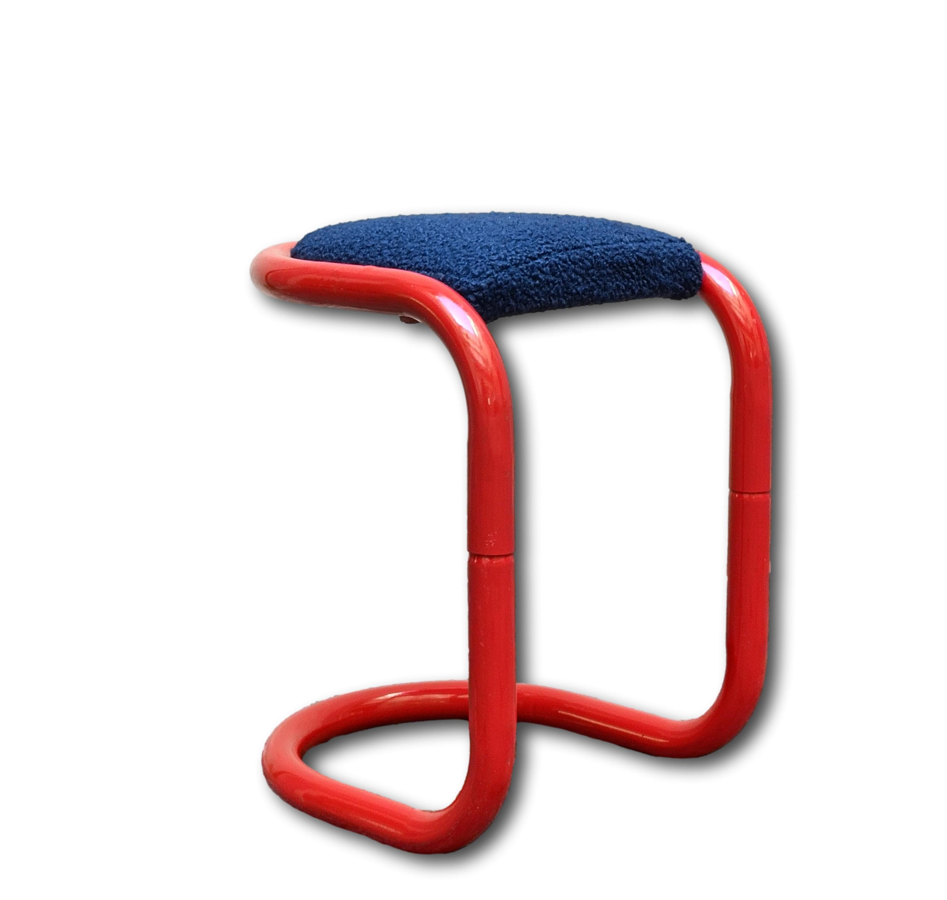 Tabouret italien des années 1970 en métal tubulaire de couleur rouge, apportant une touche de couleur à la pièce. Le design est caractérisé par des lignes courbes qui créent une silhouette fluide. L'assise est en tissu 