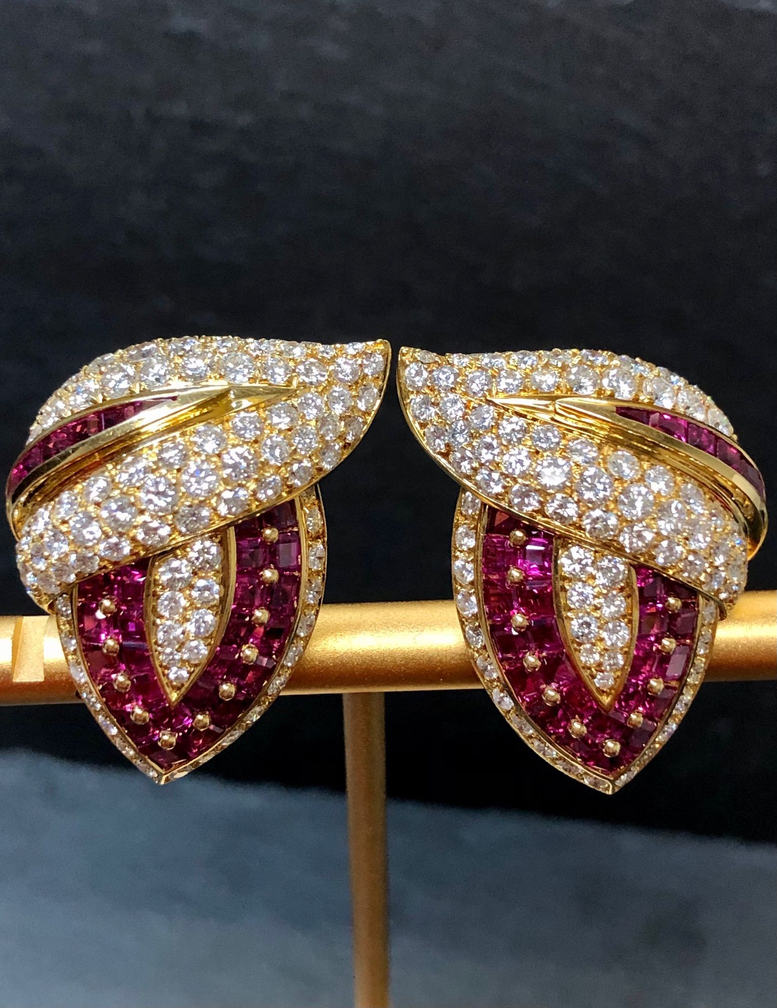 An absolutely gorgeous pair of very well made earrings done in 18K and set with approximately 6cttw in G-H color Vs1-2 clarity diamonds as well as approximately 6cttw in calibrated square cut natural rubies.

Dimensions/Weight
1.10” long by 1.10”