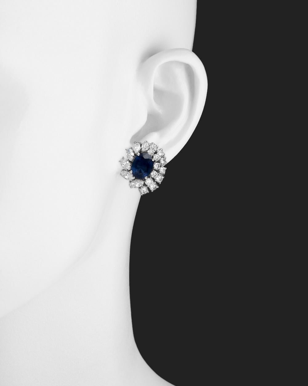 Sapphire and diamond cluster earrings, featuring a larger oval-shaped sapphire accented by round brilliant-cut and marquise-shaped diamonds, in 18k white gold, signed Giovane.
 

Two sapphires weighing ~6.65 total carats
Diamonds weighing ~5.40