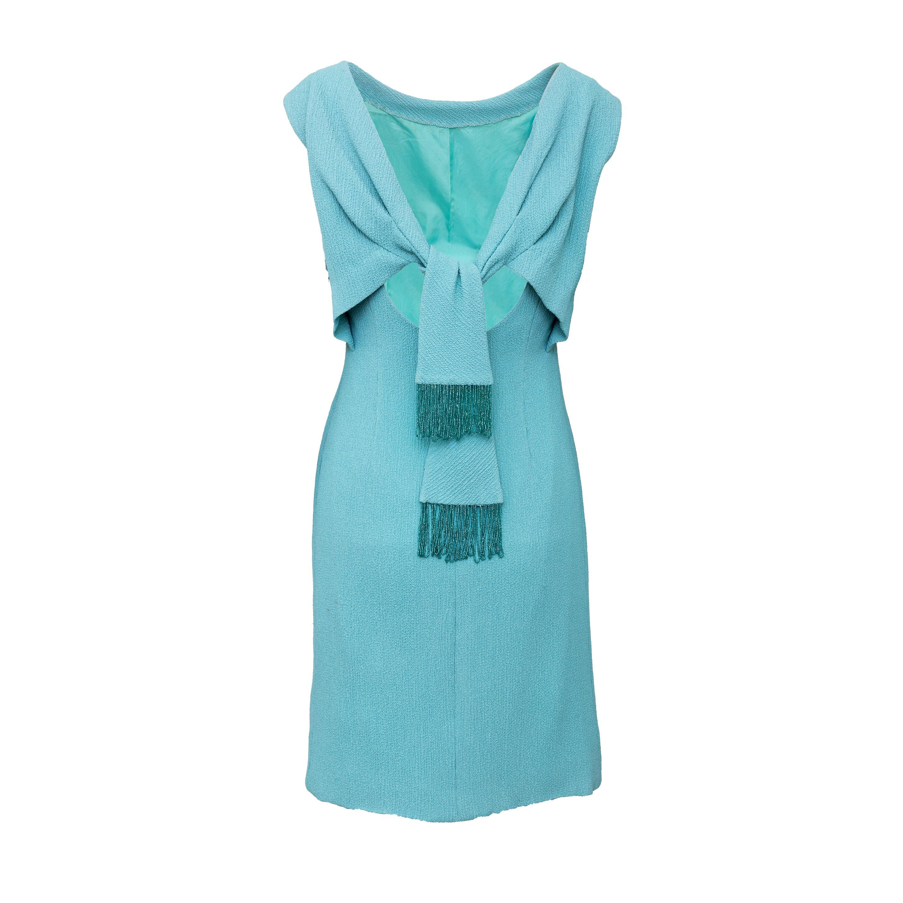 Add a touch of vintage glamour to your wardrobe with this rare 60s dress. Designed by Giovanna Ferragamo, daughter of Salvatore Ferragamo, this dress features a striking blue crepe fabric and a back pleats design adorned with two panels of beaded