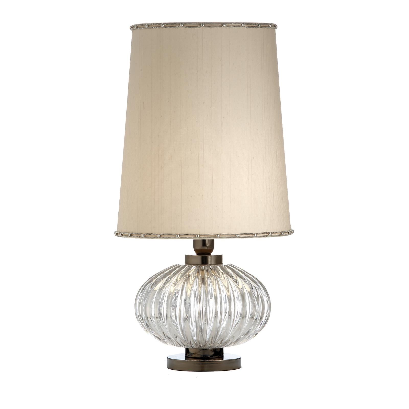 This elegant table lamp combines different textures, shapes, and proportions to give a delicate, retro-chic effect that will complement a classic or vintage-inspired interior. Resting on a structure in metal, the piece is accented with a sphere in