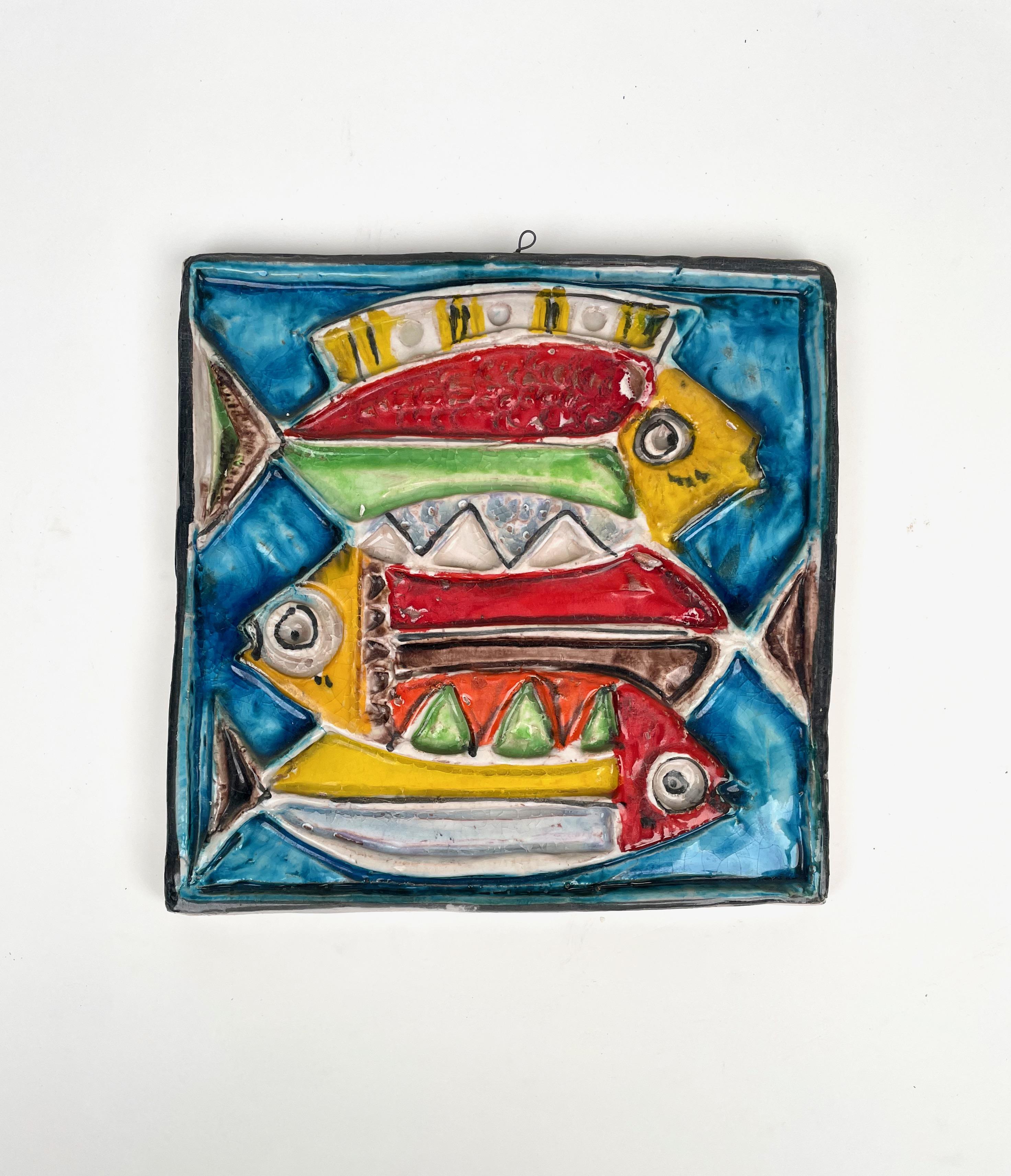 Schöner quadratischer Fliesenteller aus farbiger Keramik, der drei Fische darstellt, von dem italienischen Künstler Giovanni De Simone. 

Giovanni De Simone war ein großer sizilianischer Künstler aus Palermo, dessen Stil von den Gemälden Pablo