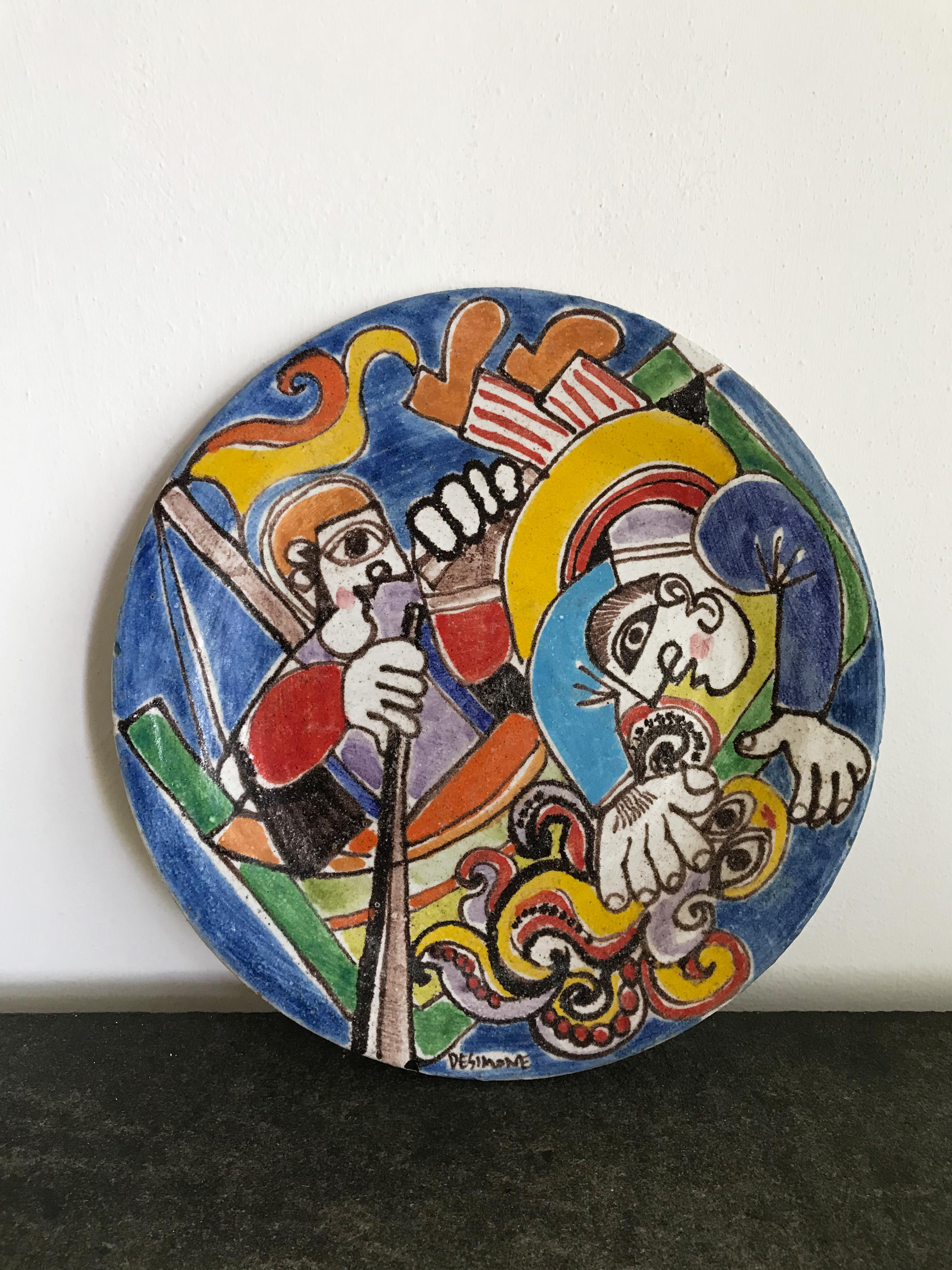 Piatto decorativo a parete o centrotavola in ceramica decorato a mano, vintage di modernariato, disegnato dall’artista italiano Giovanni De Simone e prodotto dal suo laboratorio, firma dell’autore sul bordo e sul retro, Italia anni 50

Giovanni De