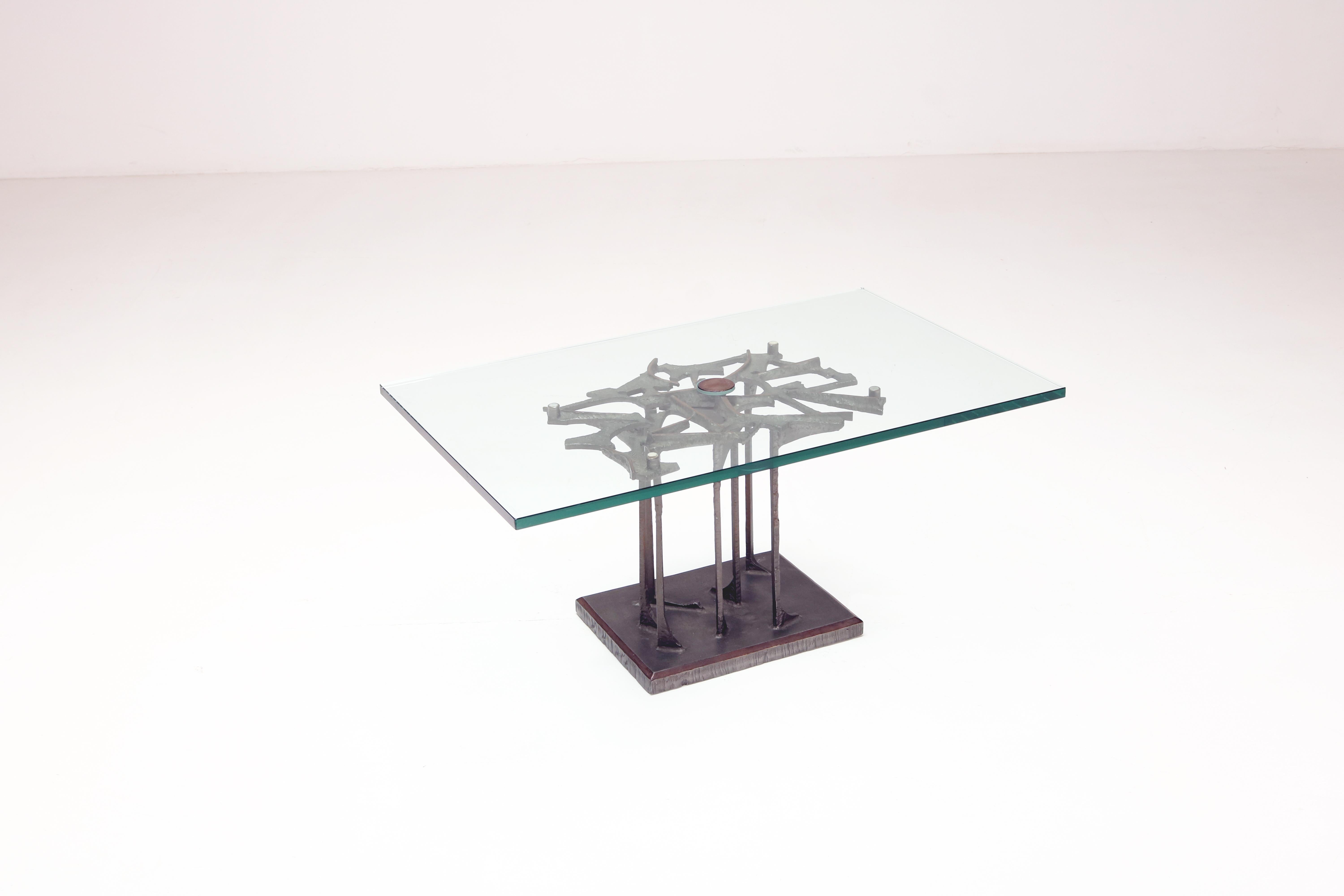 A low table with a strongly decorative character, this unique piece features a finely crafted bronze base decorated with a brutalist but also floral motif, with a base with solid roots and fine bronze stems supporting an intricate weave of branches