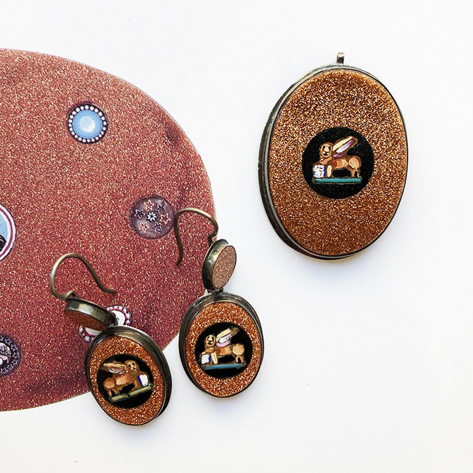 A set consisting of a pair of earrings and a pendant made of a glass micro-mosaic lion on a circular black background.

Weight earrings: 3.79 grams
Dimensions earrings: 3.6 x 1.6 cm
Weight pendant: 5.71 grams
Dimensions pendant: 3.6 x 2.6