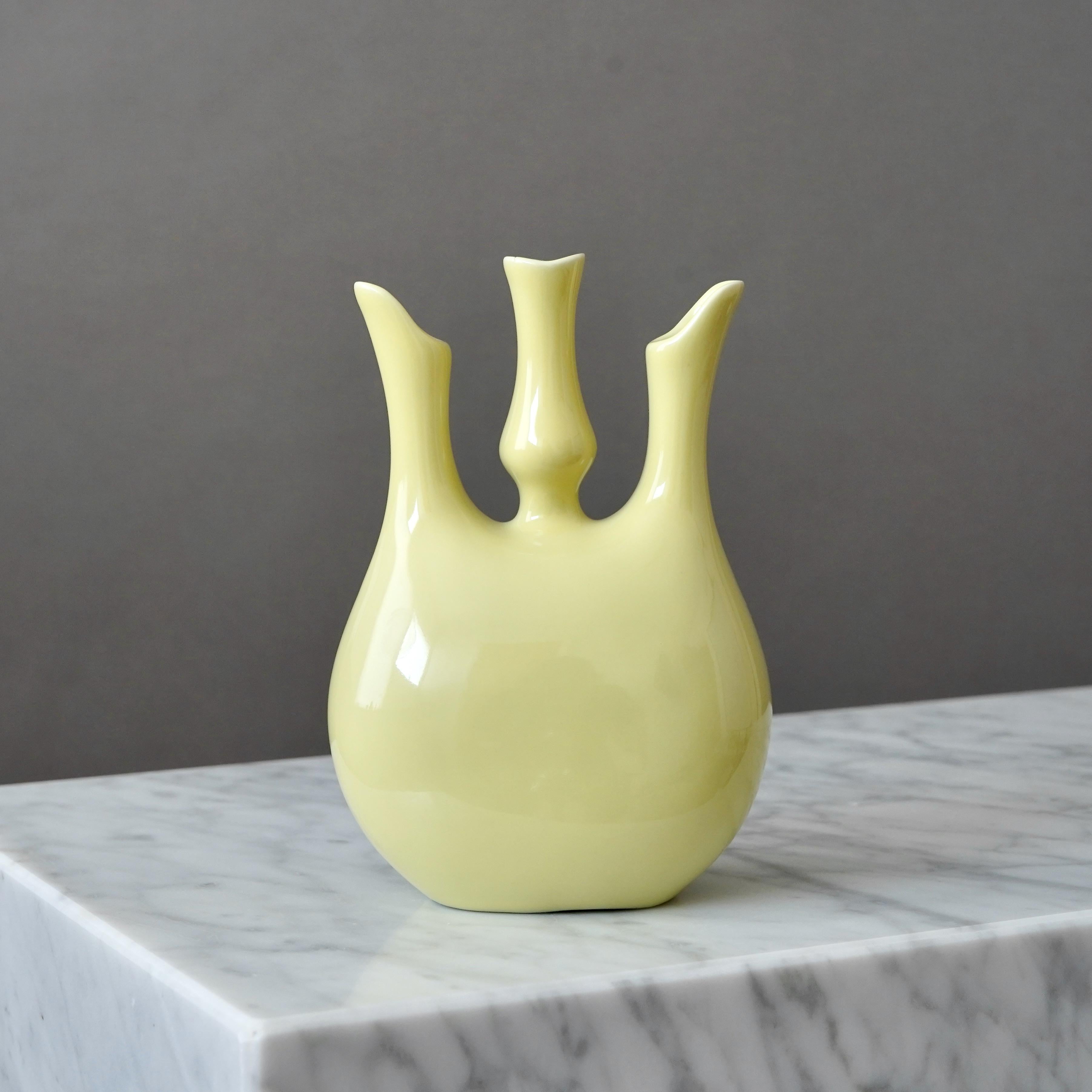 A beautiful, sculptural three-necked 'Ariston' ceramic vase with yellow glaze.
Designed by Giovanni Gariboldi for Richard Ginori, Milan, Italy, early 1950s.

Good condition. A tiny firing crack under the glaze in one of the mouths.
Stamped with