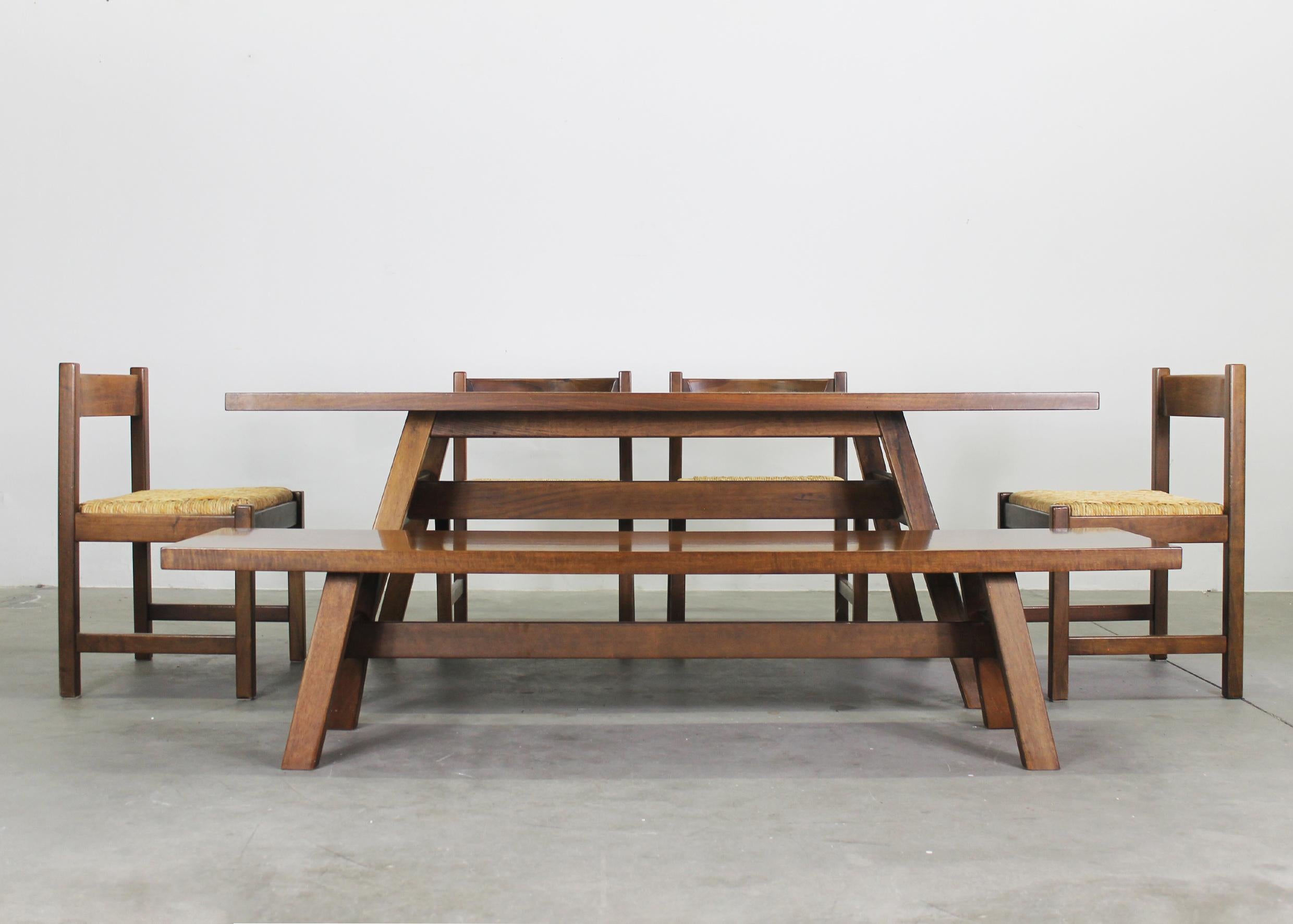 L'ensemble de salle à manger ROOMS est composé de quatre chaises, d'une table et d'un banc.
La table et le banc ont été fabriqués en bois de noyer, les chaises ont une structure en bois de noyer et des sièges tissés. 

Chaque pièce de cet ensemble