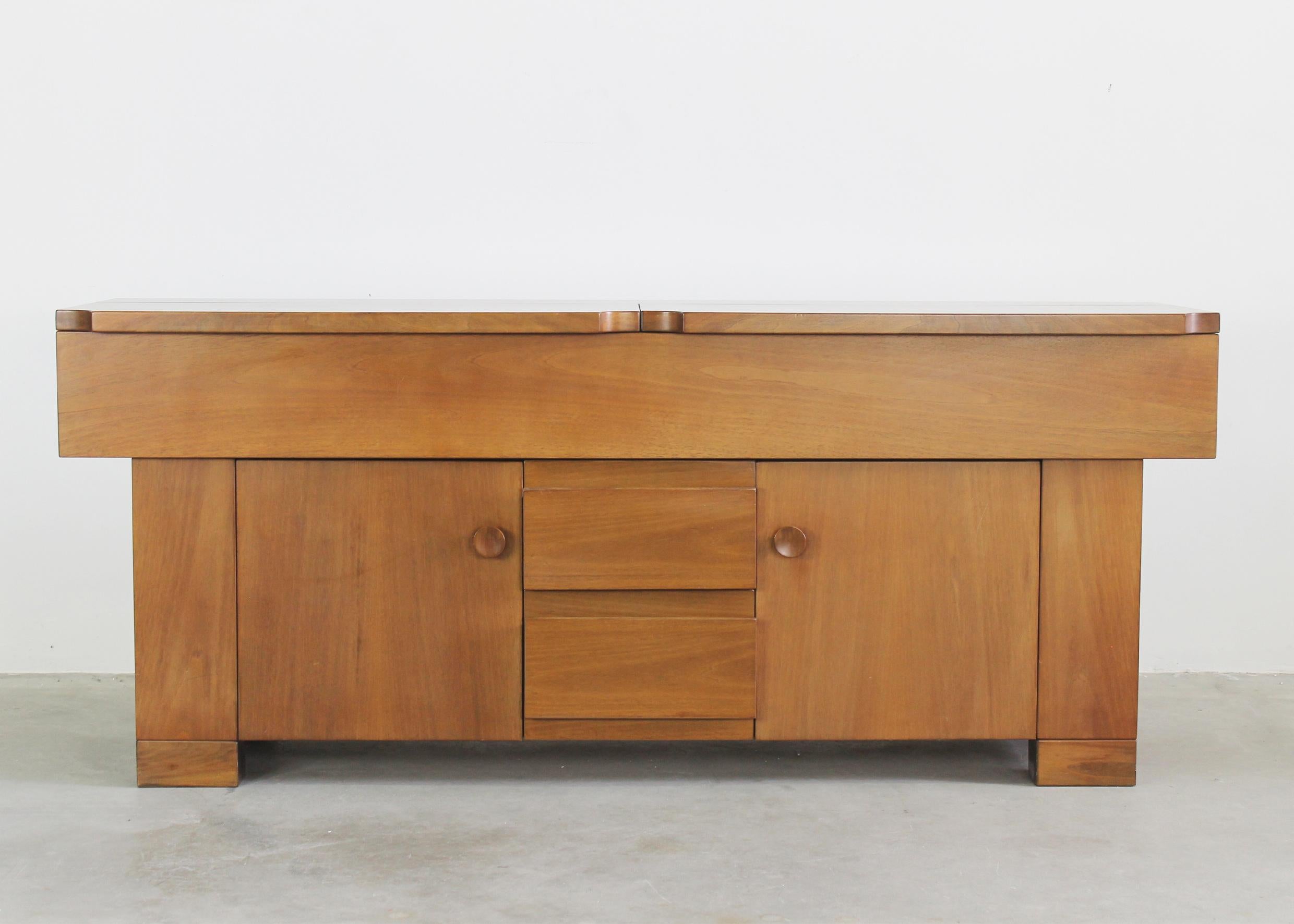 Torbecchia sideboard is entirely realized in solid veneered walnut wood, with two frontal hinging doors (inner shelves), two drawers, and a storage unit under the openable top part.

The signature of Giovanni Michelucci is visible on a sideboard