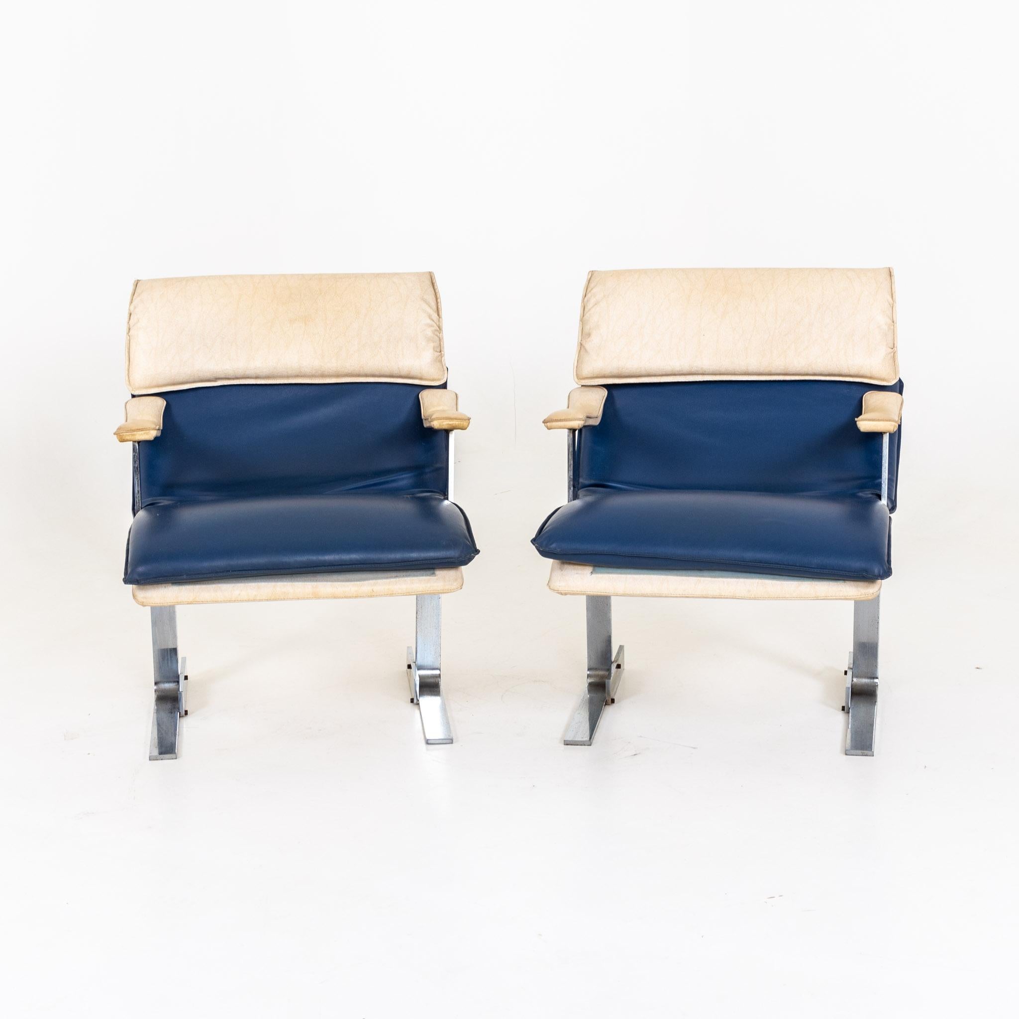 Armchairs with leather upholstery in blue and beige on metal frame. Signs of age and use.