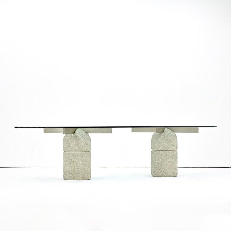 Giovanni Offredi for Saporiti 'Paracarro' dining table.

Made in Italy, circa 1970s.

Two concrete bases with rounded glass surface

Measures: Dining table glass- 29 H x 126 L x 48 W inches.
