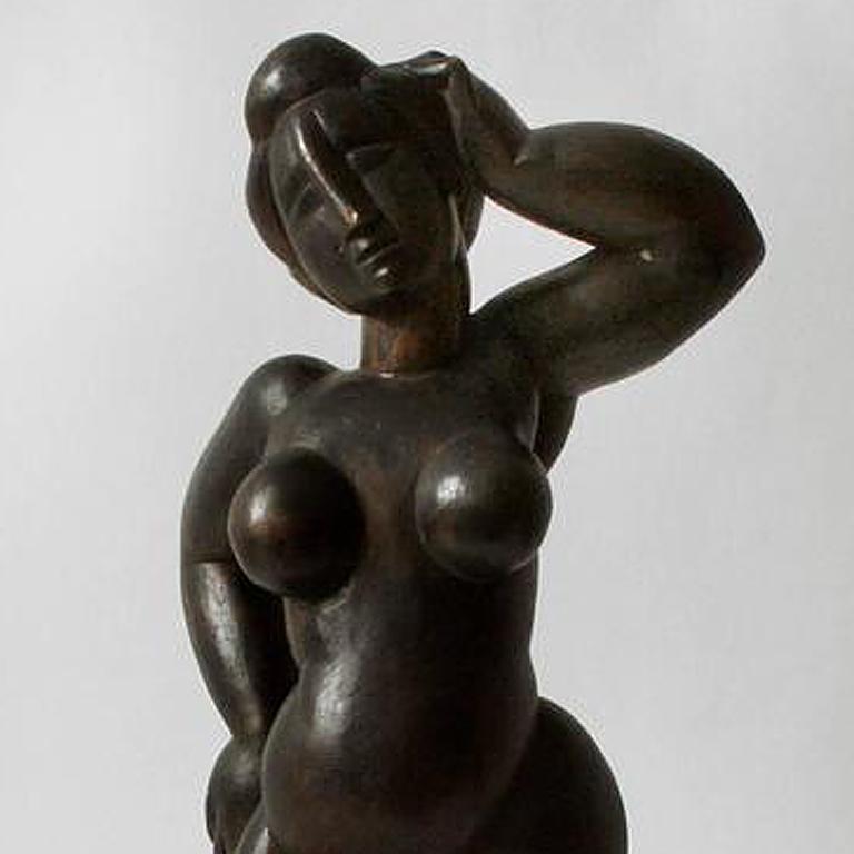 This outstanding elegant sculpture by the Italian artist Guiseppe Rindler is executed in bronze with black patina and depicts the figure of a nude woman standing in a virtuoso manner touching her head with her left hand. The artfully arrangement of